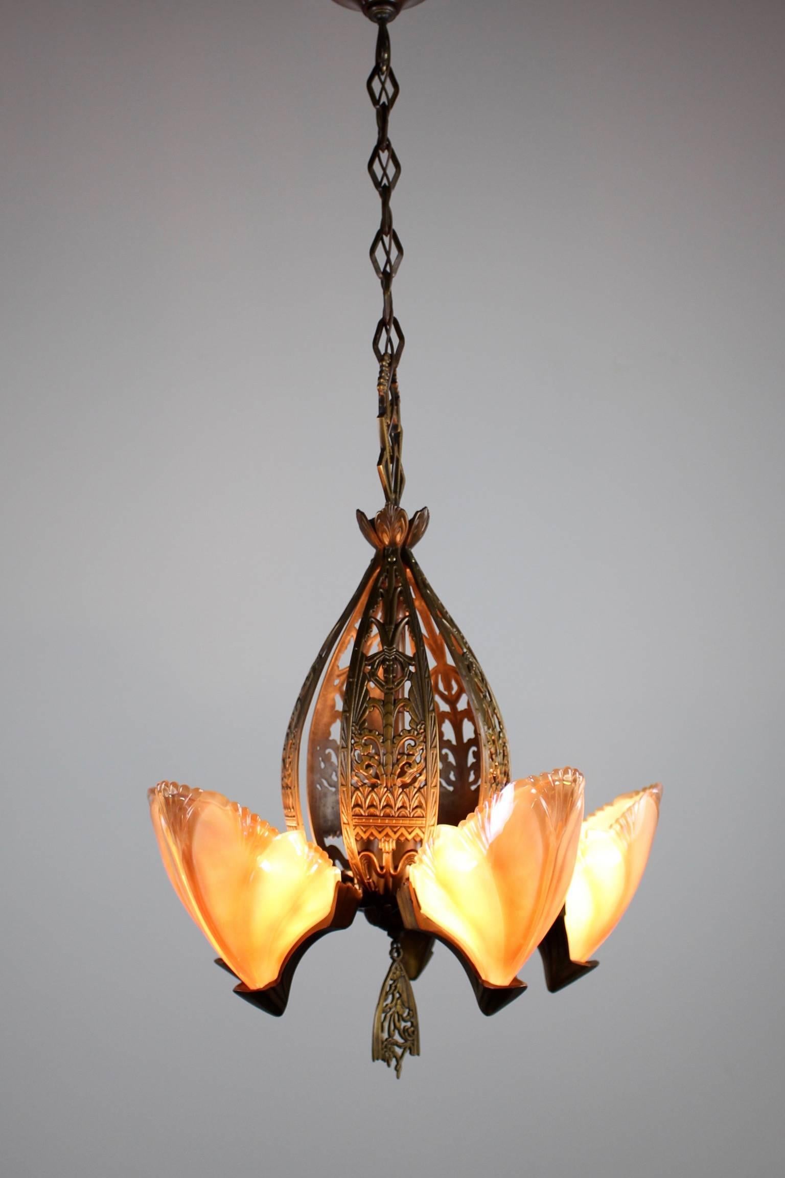 An absolutely beautiful and original Art Deco slip-shade fixture with five slip shades original to the fixture. These gorgeous shades are in a shiny 'oyster' coloured iridescent semi-opaque glass. Gorgeously decorated cut-out brass body in a warm