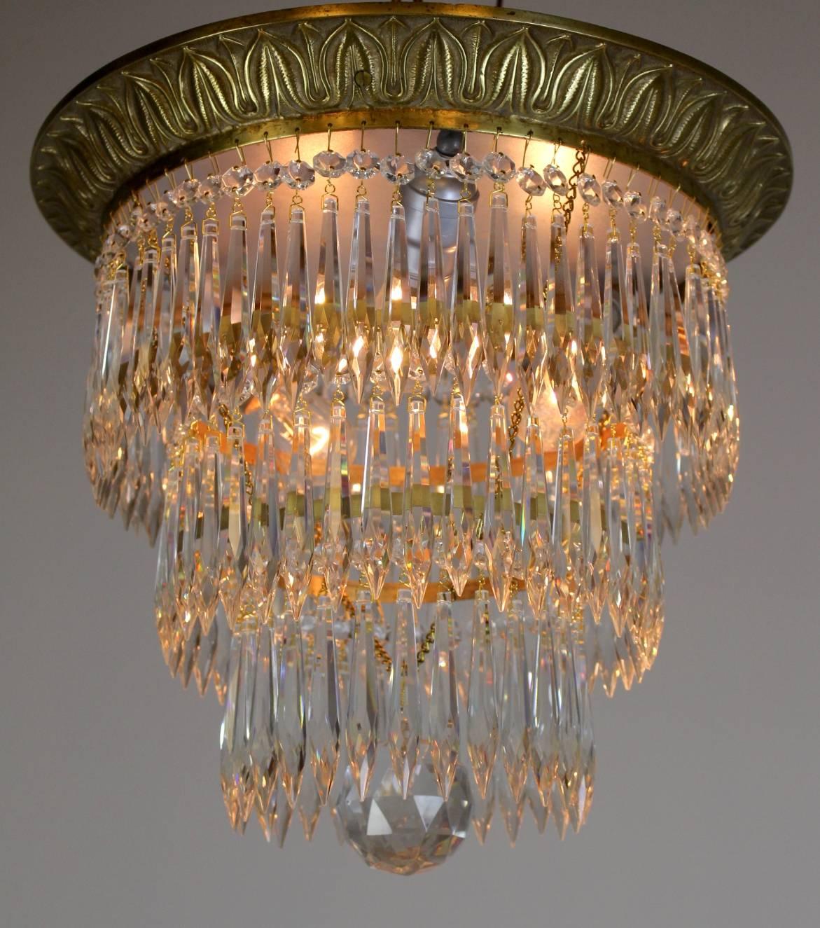 High quality cast brass rimmed crystal flush mount, made circa 1915.

Classical Revival / Beaux Arts in Style, This gorgeous fixture boasts three tiers of cut crystals and a large central cut ball.

Finished in a rich Satin gold