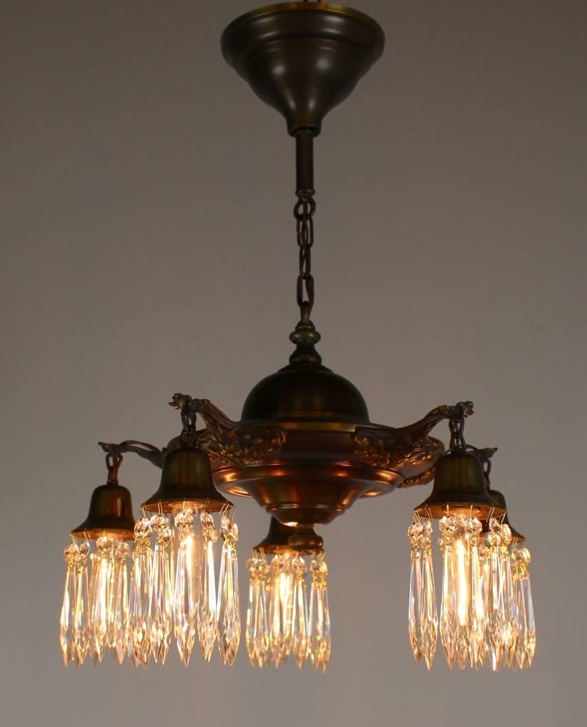 Lovely five-light pan fixture with highlighted arm details,

finished in an Antique Brass colour and complemented with crystal holders.

Measures: 27