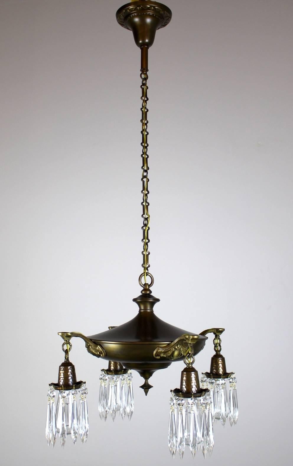Sturdy four-light pan fixture, circa 1915, this light is finished in a two tone antique brass with details highlighted.
The decorative chain and crystals hanging from each of the hammered bulb holders really set this fixture off.
Measures: 43
