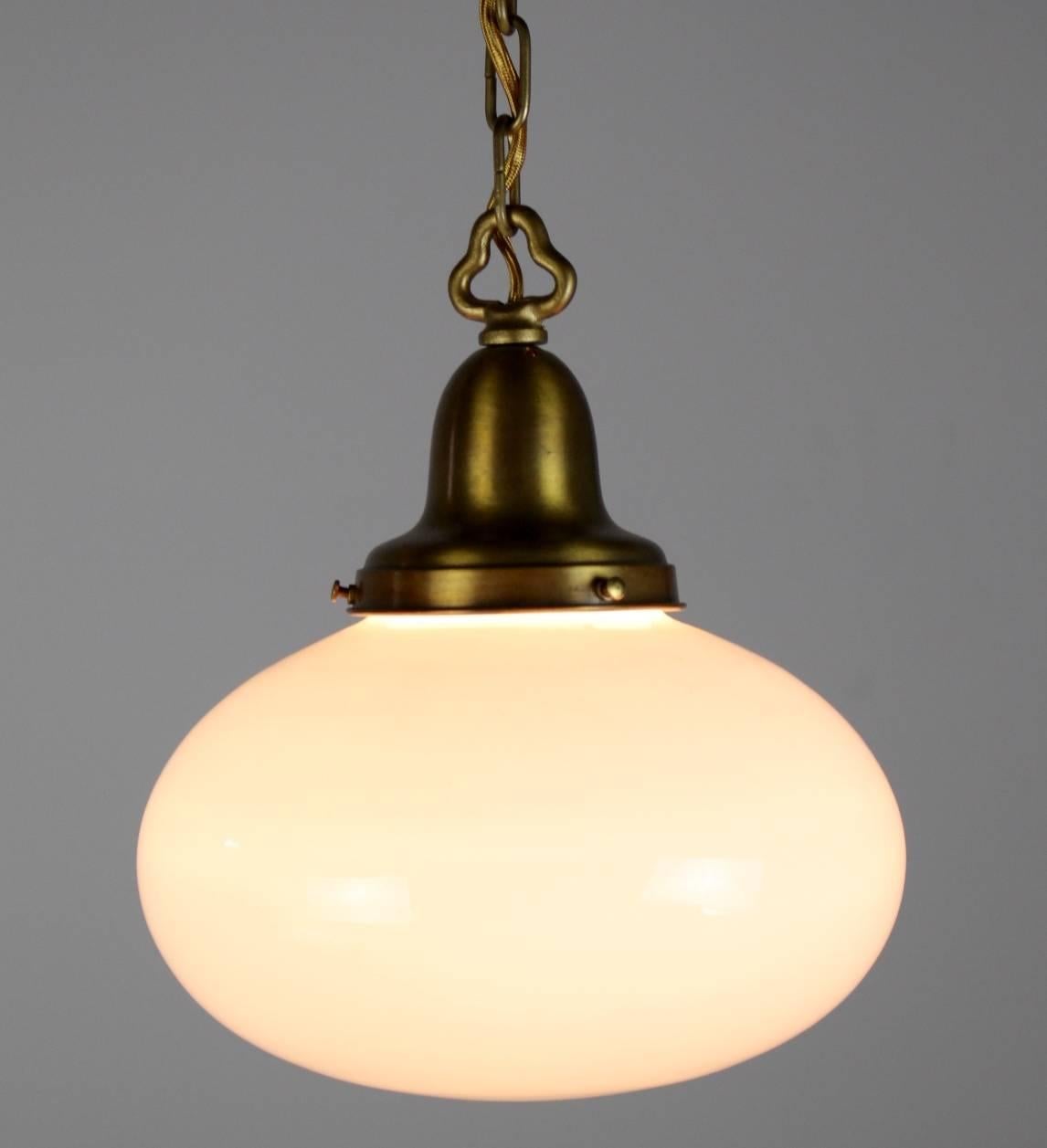 Lovely, simple pendant globe fixture.
Finished in a light olive bronze with oval white glass globe shade, 
circa 1925
Measures: 36