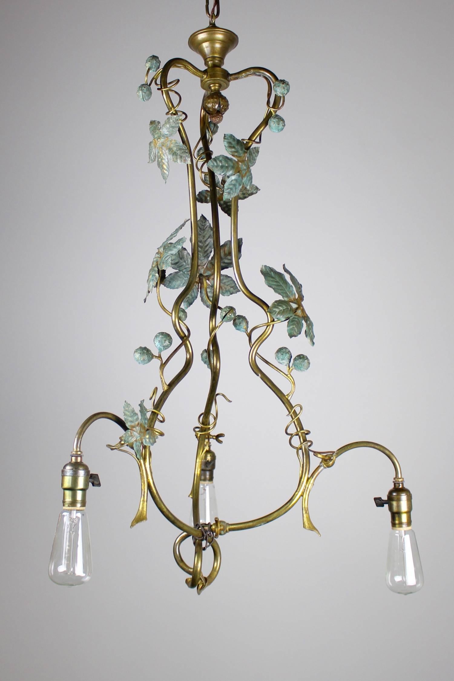 This converted gas-electric fixture, circa 1910. Constructed in an extremely organic manner, the light has the appearance of having just grown out of the ceiling. The light is fitted with three tungsten bulbs, and showcases a leafy arrangement of