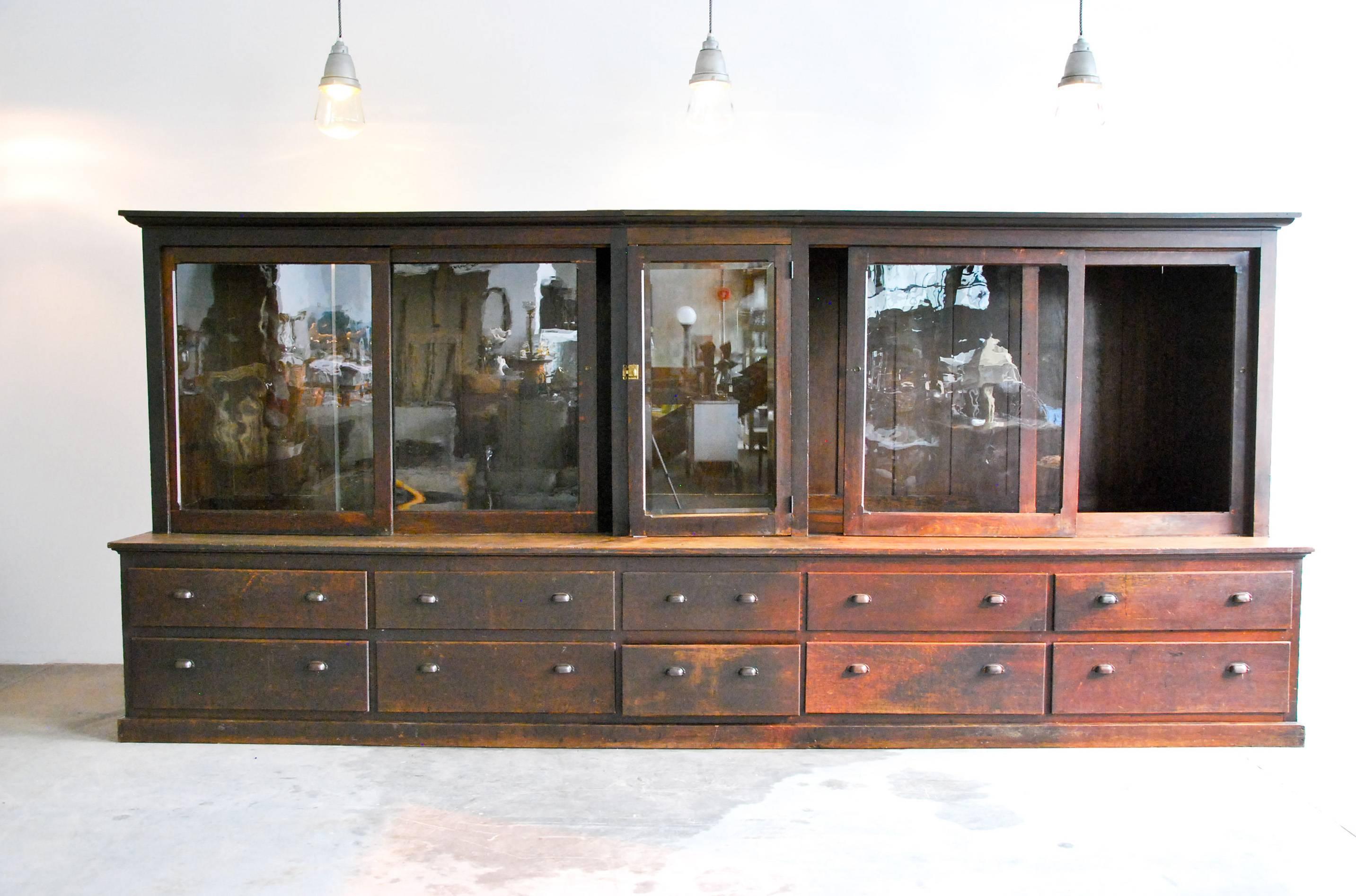 Exceptional display cabinet in original finish over oak, with sliding doors and ten working drawers for storage of goods.
This piece has the ability to have a centre featured display with adjustable shelves on two side pieces.
The cabinet is