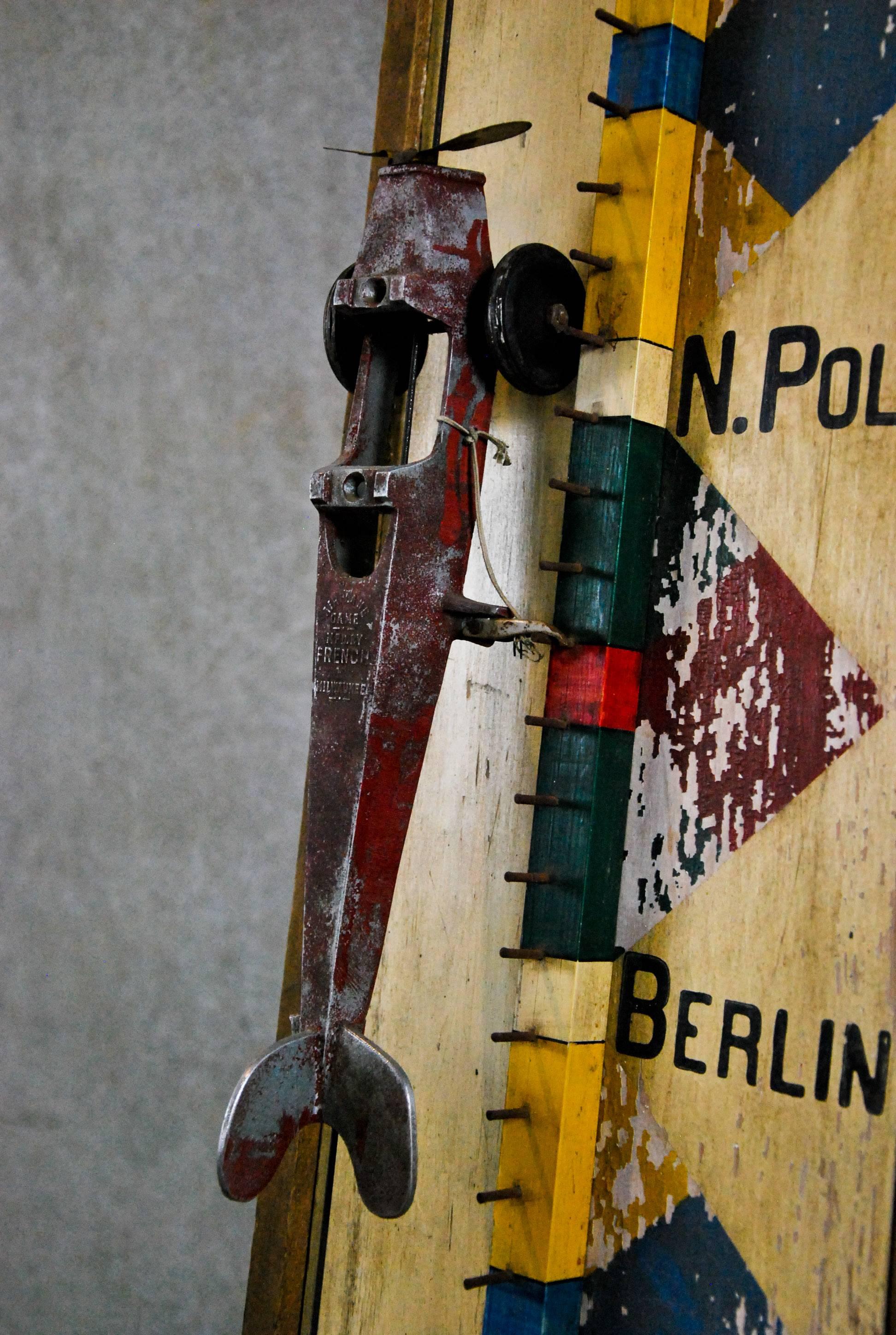 Ungewöhnliches Folk Art Holzspiel in funktionierendem Zustand und mit Originalfarbe. Die Spieler wetten darauf, auf welcher Stadt das im Frühjahr freigelassene Flugzeug landen wird. Hergestellt von French Game & Novelty Co. in Milwaukee, WI.