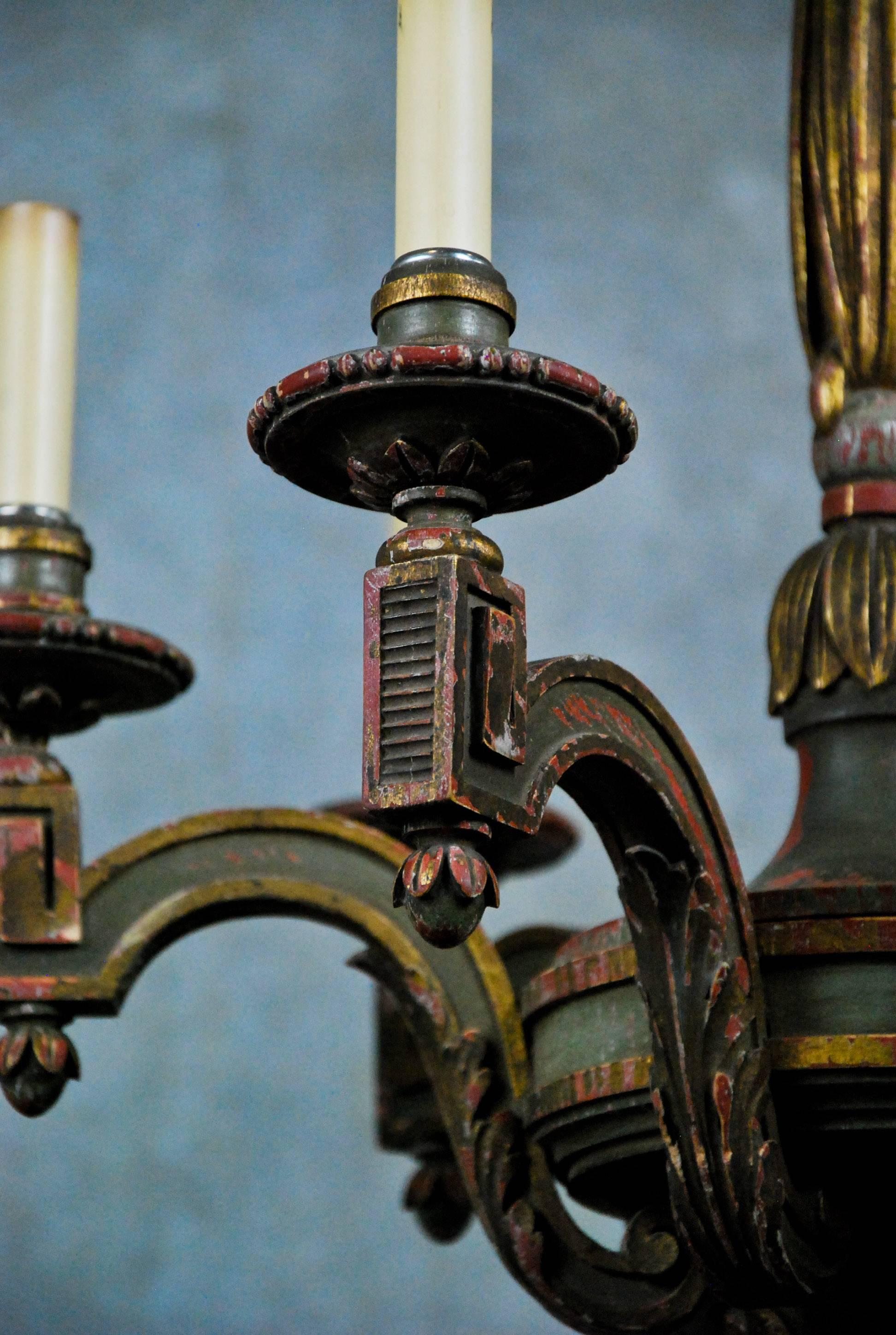 Polychromed and partial gilded chandelier, six carved wood candle arms carved with acanthus leaf and strong Greek key influence, each arm is anchored by decorative finials.
Chandelier has been electrified and csa approved.