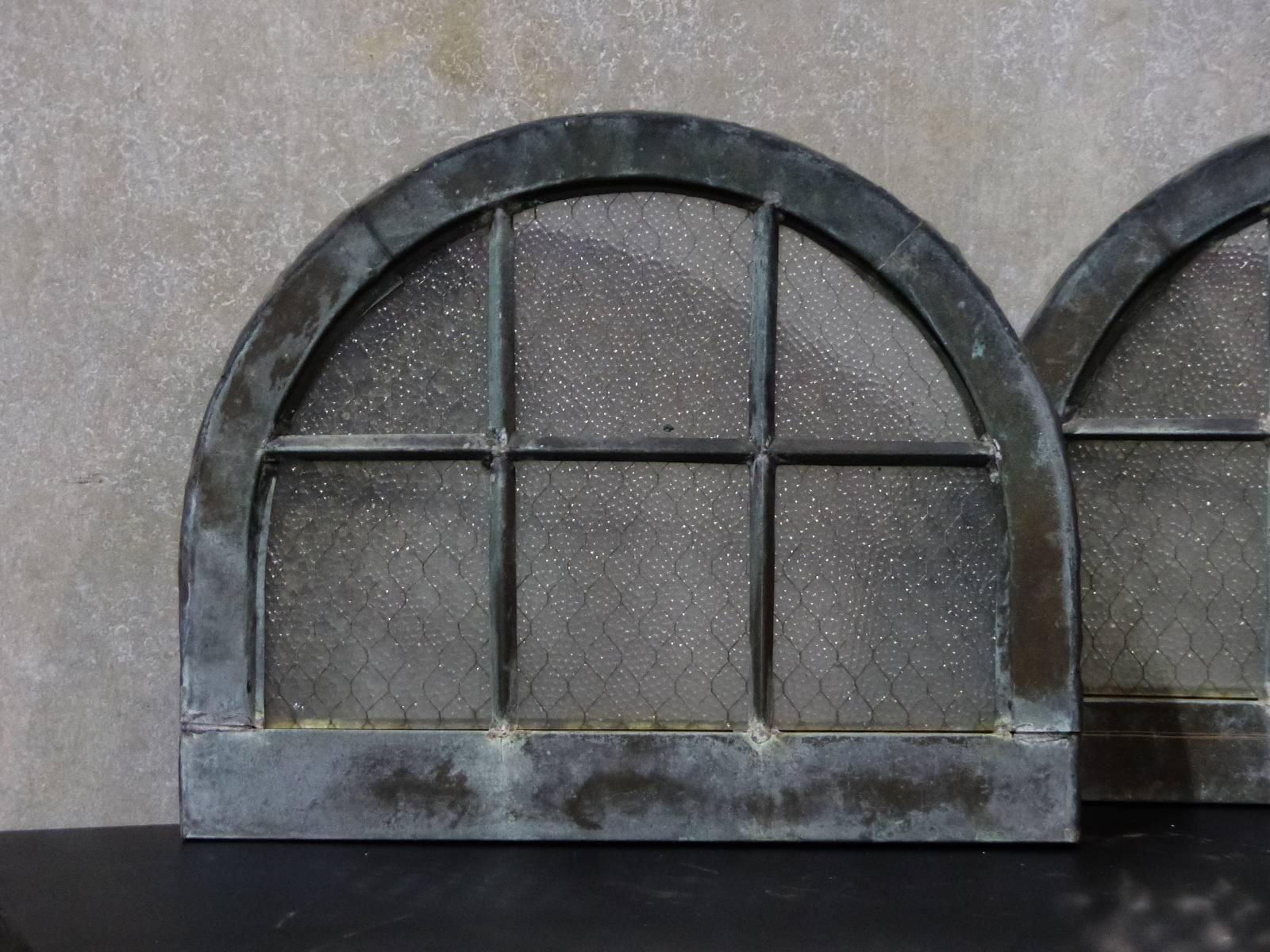 Pair of small arched glass window panels with original safety glass , salvaged from The Greystone Institution in New jersey.

Window frames are copper cladded . c 1890