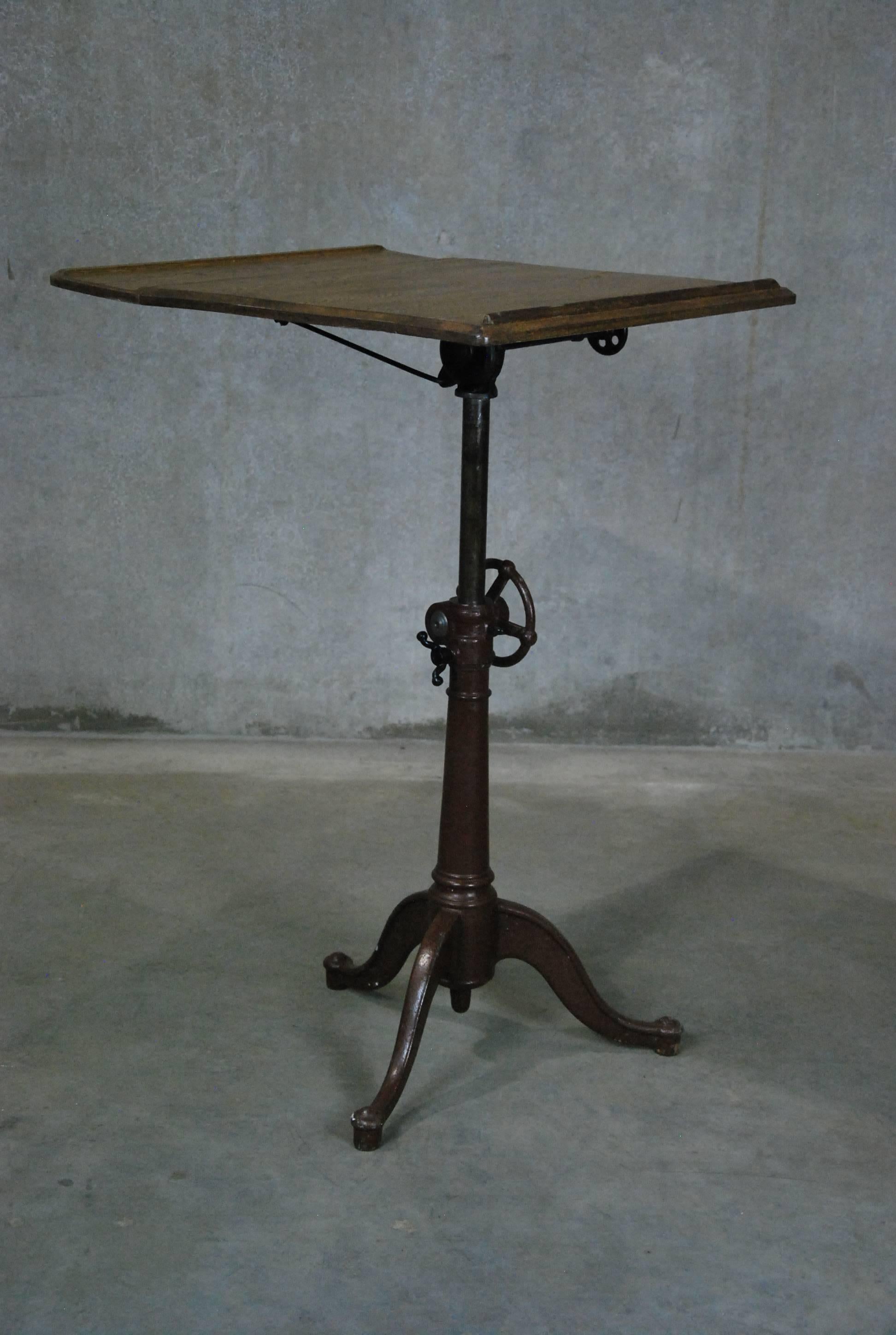 Beautiful adjustable American made drafting table manufactured by the Washburn shops. This example is perfect condition with fully functioning hardware. Would make a great hostess stand in a restaurant.

The Washburn Shops was built in 1868 along