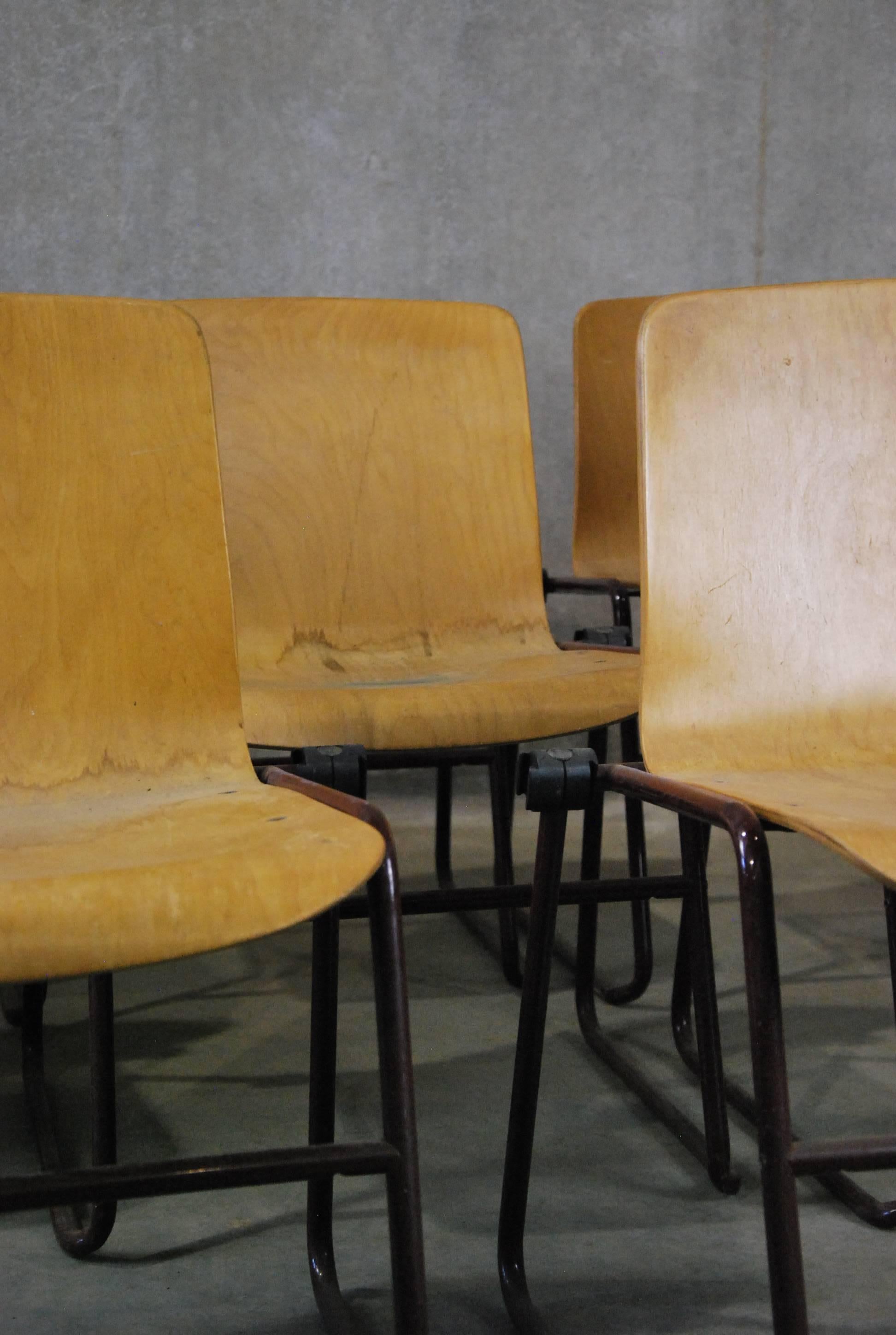 These unusual Kinetics bent plywood chairs were made in the 1980s, although their look is Mid-Century Modern. The iron legs have a locking mechanism that allows you to connect the chairs, if desired. Made in Canada by J. Hayward. Quantity of eight