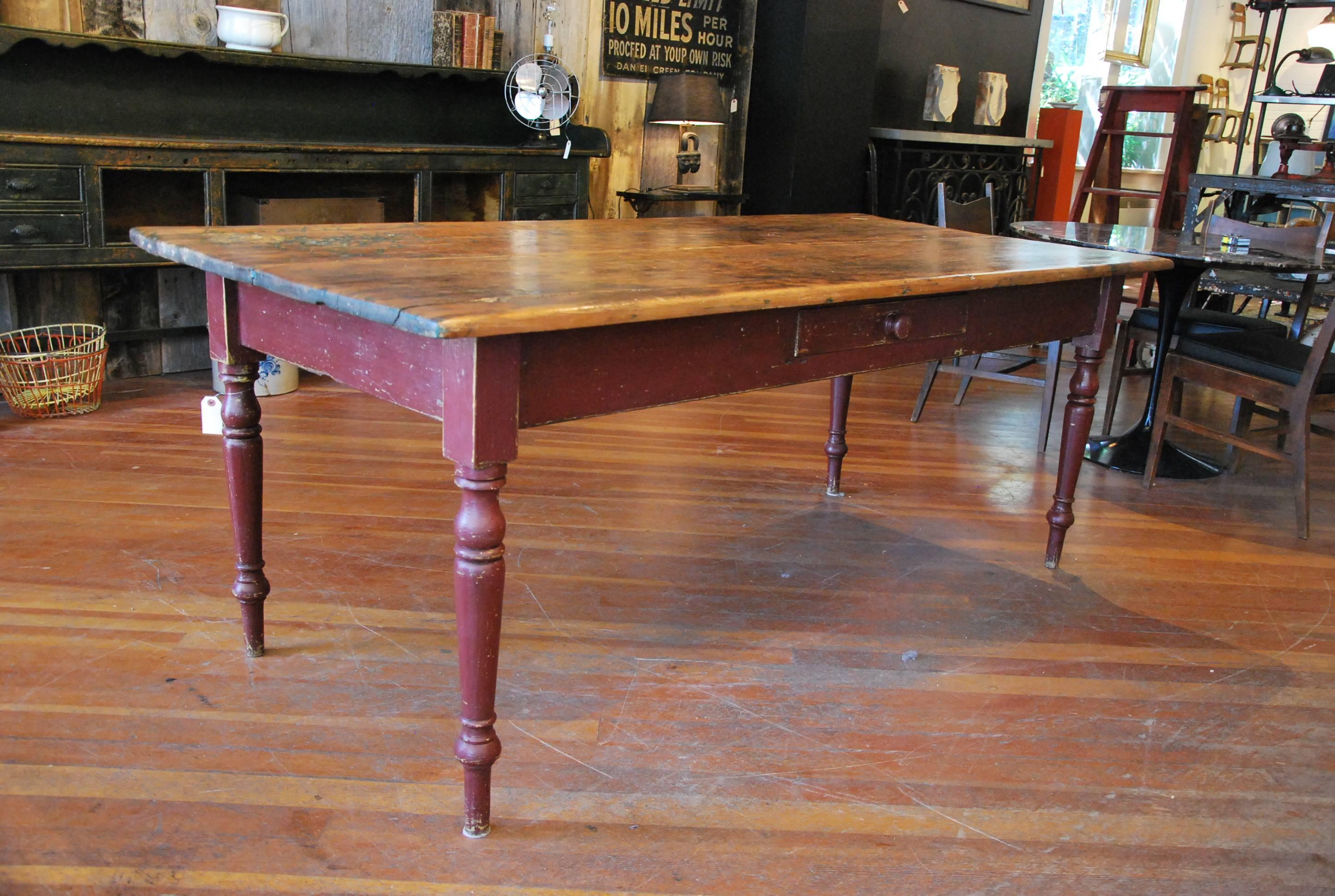 Very nice two board top authentic turned leg harvest table, with well-worn top and working utility drawer. Surface has a wax finish.
The base is polychromatic paint with an old red over blue green.

Found in Eastern Ontario, Canada.
Recently