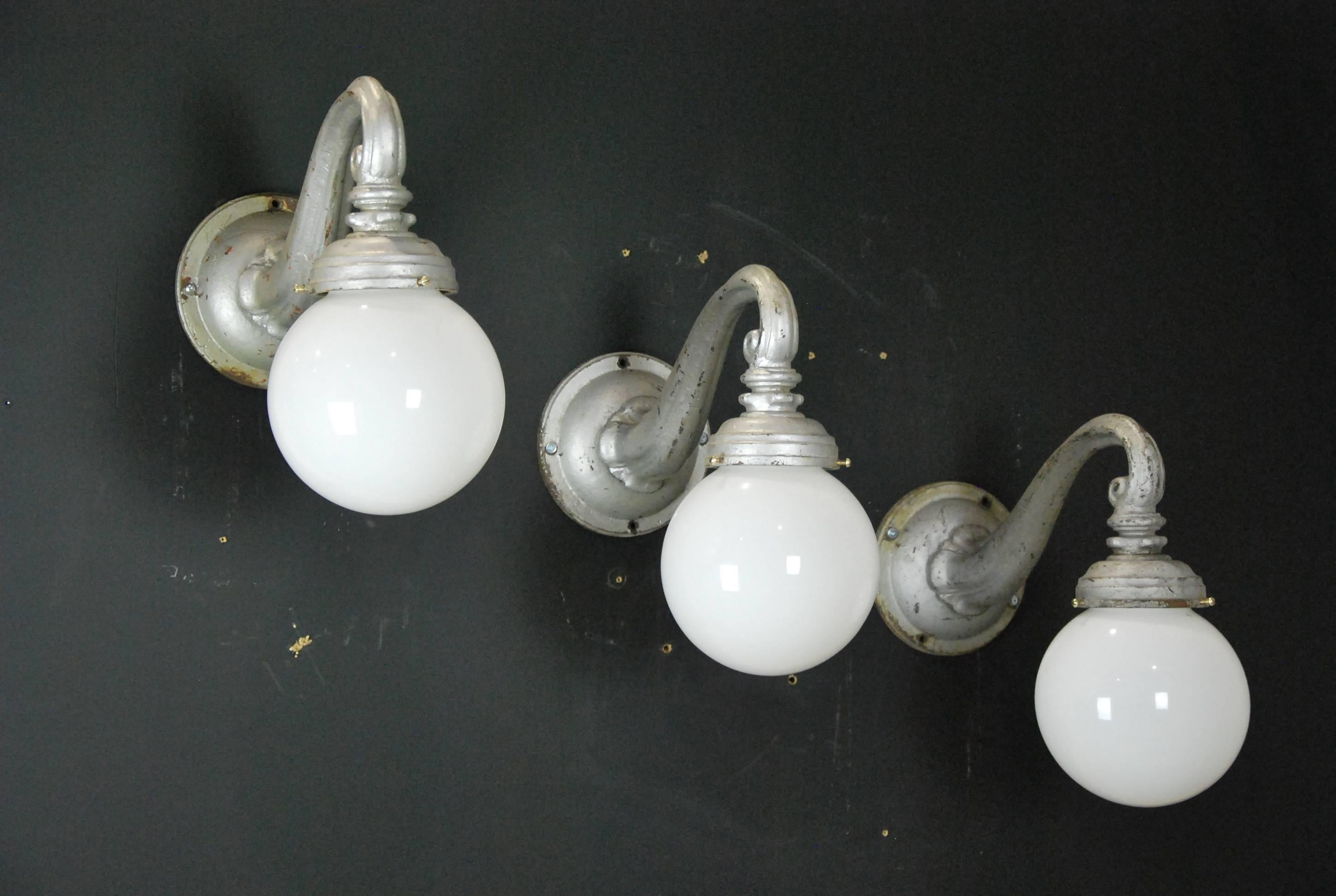 Nice clean set of original outdoor sconces made of cast iron with 8-inch simple white milk shade globe. Retains several layers of old paint.
This set was salvaged from an early building in Montreal.

Rewired and CSA approved.