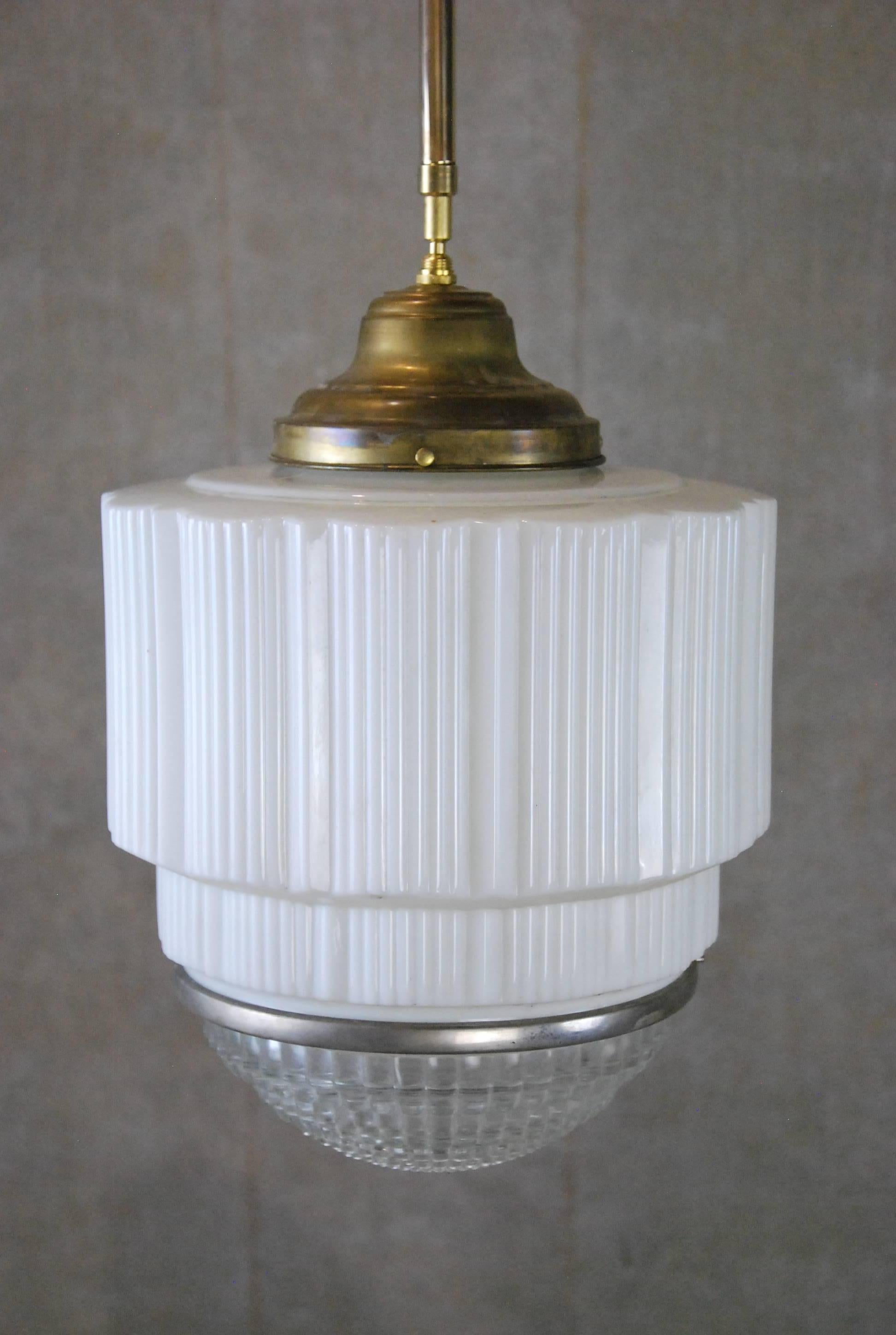 We have a set of three large oversized deco lights with brass fitters on a combined pipe and chain to allow for easy custom height requirements.
Found in a bank in Toronto years ago.
 Art Deco electric light, translucent white ribbed shade /