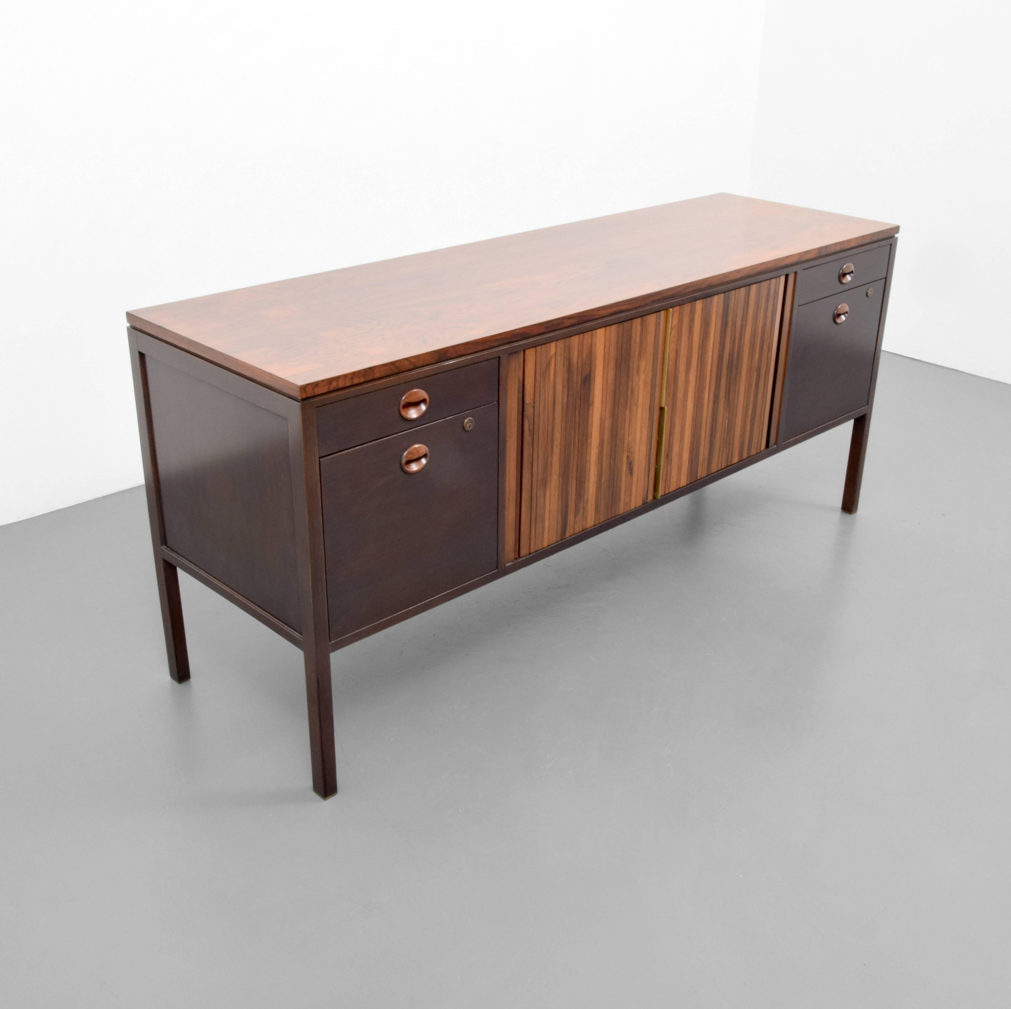 Cabinet by Edward Wormley for Dunbar. Cabinet has two drawers, two file drawers and two tambour doors revealing a shelf.

Cabinet is marked. 

Edward Wormley's furniture designs utilized quality materials and were understated and well-made,