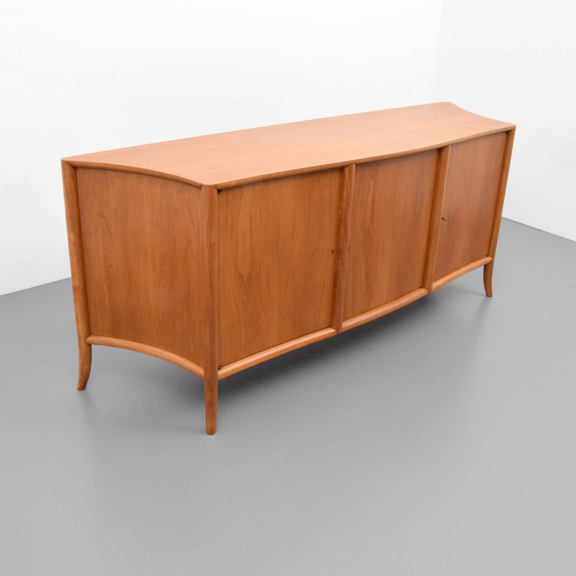 Cabinet/server by T.H. Robsjohn Gibbings for Widdicomb. Cabinet has saber/splayed legs and three keyed doors revealing a total of four pull-out drawers and three adjustable shelves.

T. H. Robsjohn Gibbings’ design is known for elegance and stature.