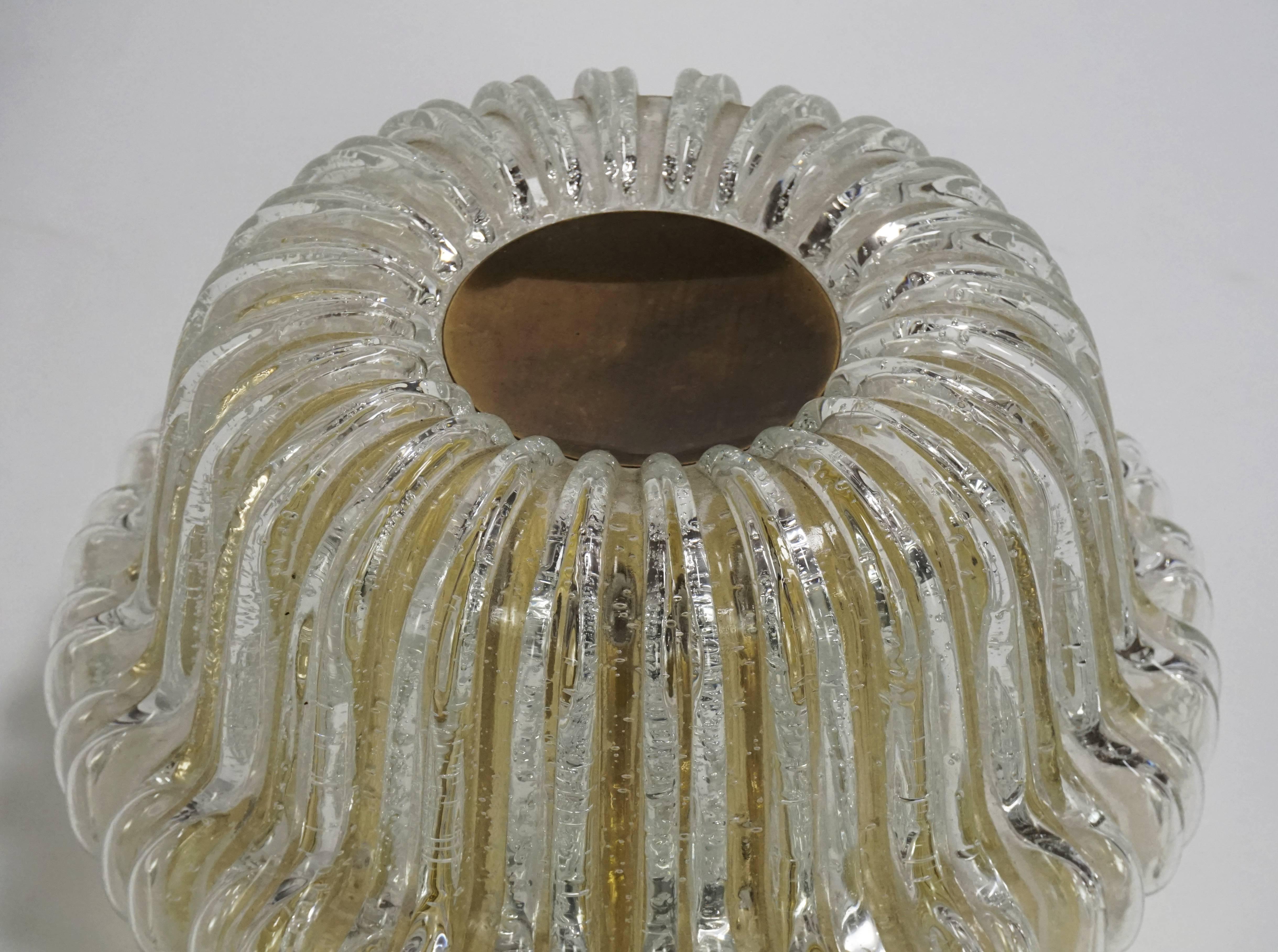 This is a beautifully shaped, Italian style flush mount by Helena Tynell, comprised of bubbled, molded glass with brass accents.  Newly rewired, (UL listing available). Single medium based socket.