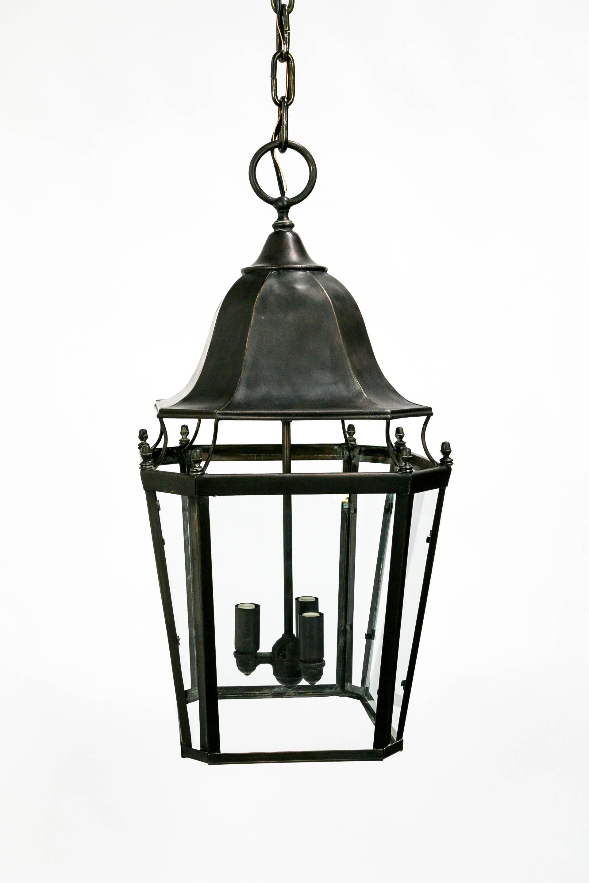 Fabulous, three-light, colonial style lantern of the mid-20th century. Eight-sided with fluted cap and corners and lovely acorn details. Glass encased. Newly wired. Measures: 24