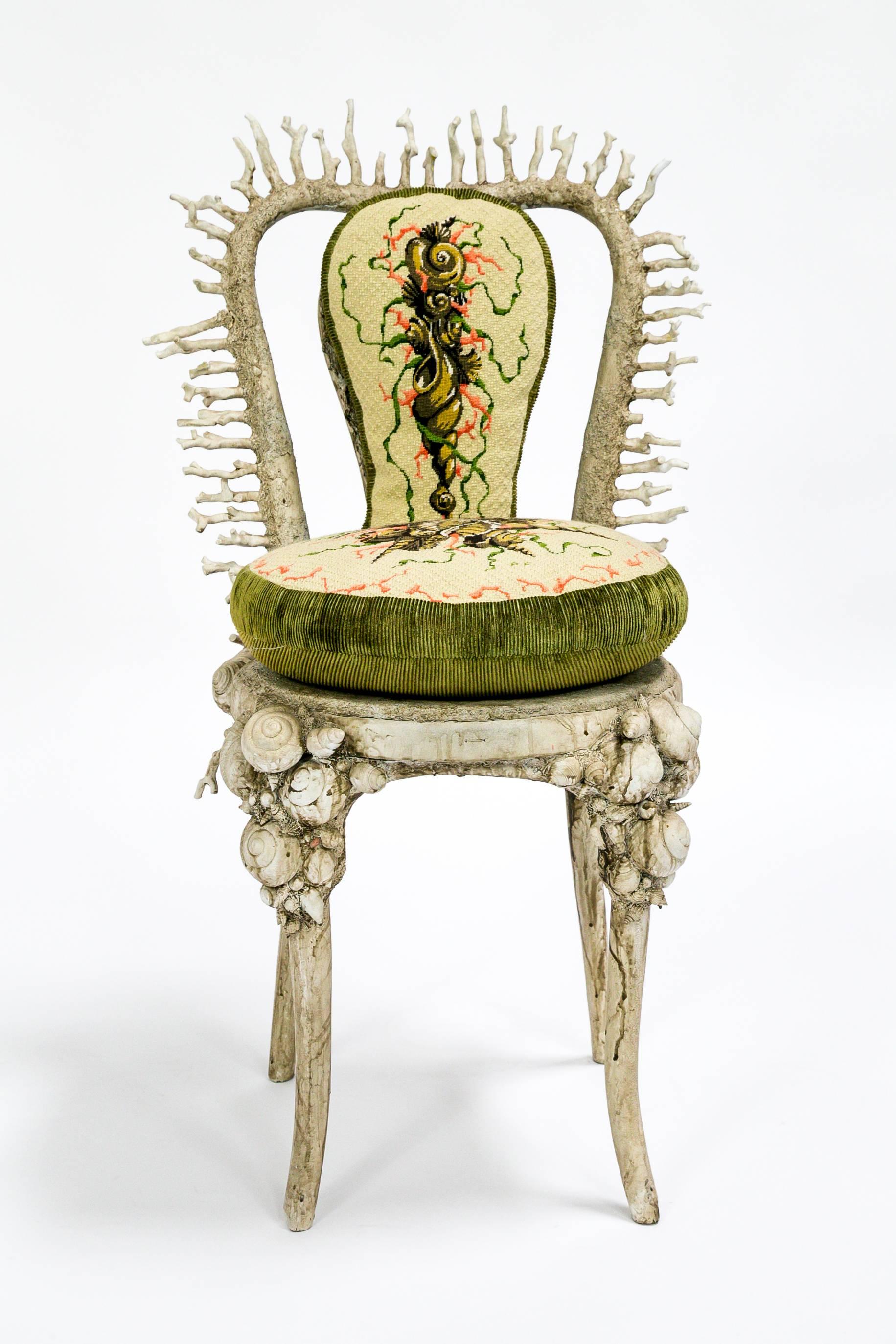 This extraordinary chair is encrusted with real shells and coral, and integrated with seamlessly with resin and paint. Its custom designed incredibly detailed, needlepoint pillows are perfectly fitted to the chair. The hand-painted finish was done