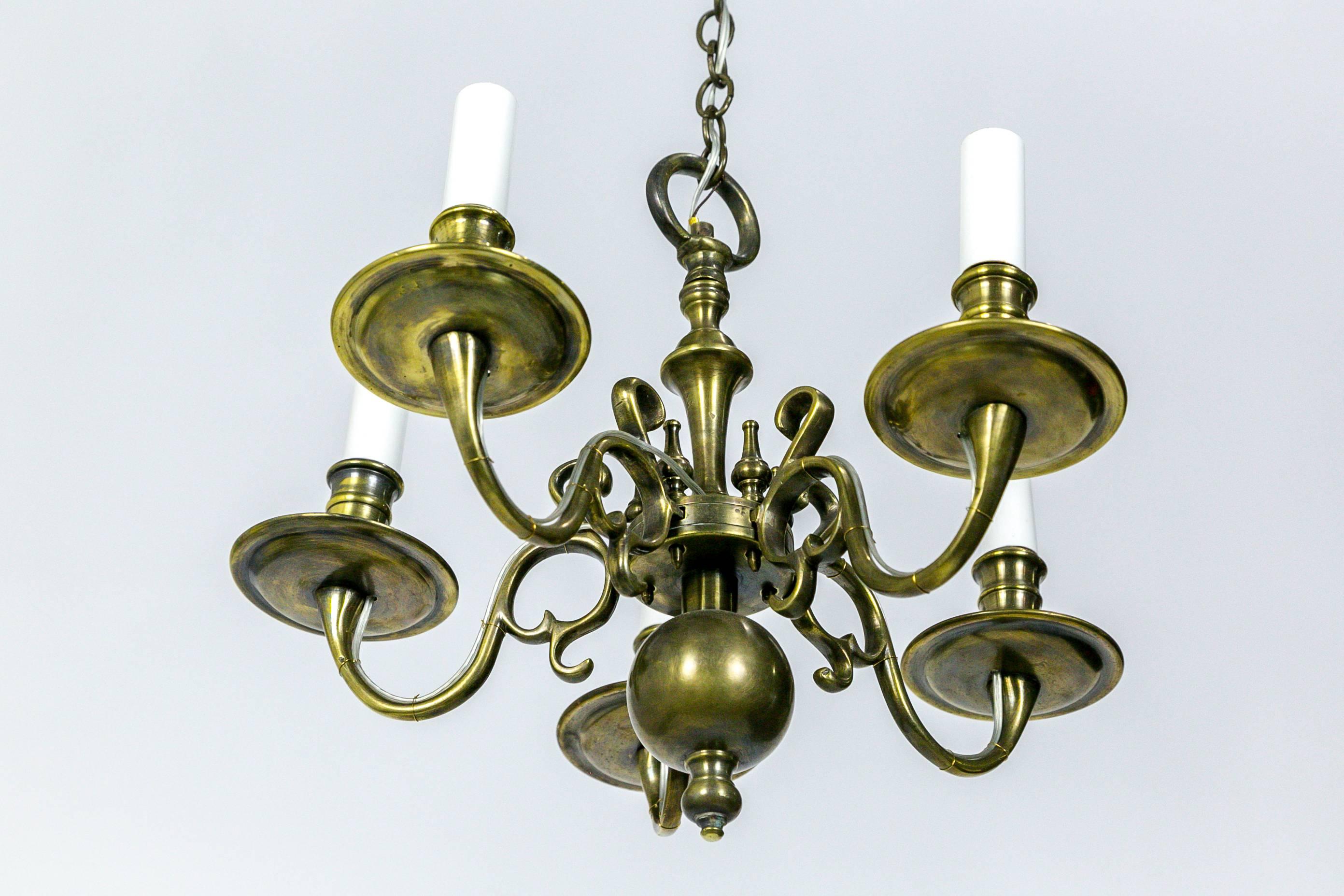 This finest of Colonial Williamsburg brass chandeliers is delicate in size and versatile for many areas of a home to display an intimate, refined feel. It has 5 lights and is newly rewired. Gorgeous finish, excellent condition. Original chain and