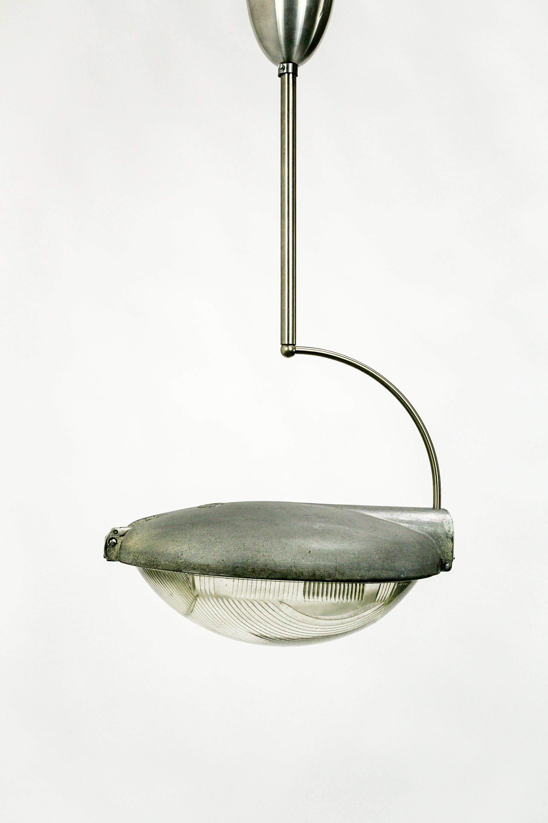 An aluminium street light by Phillips Factory of Holland made into a pendant light with a unique, hook-like stem.  The Holophane glass has an interesting, split pattern.  This piece has a contemporary look with and industrial edge. 1950's