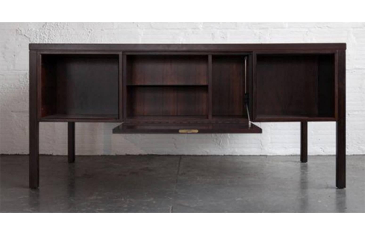 Danish Modern rosewood desk by Gunni Omann. Three drawers on left side, one-drawer for files on the right side, all lockable with included key.
Drop down locking cabinet in front to store anything privately.

This Mid-Century piece has been