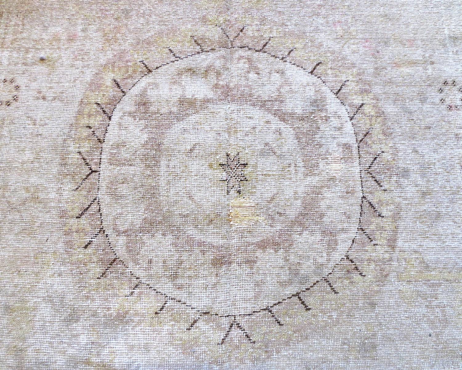 Dies ist ein antiker Khotan-Teppich aus Ostturkestan, ca. 1870. Es zeichnet sich durch drei große runde Medaillons aus, von denen jedes in einem anderen Design stilisiert ist, das auf einem schönen lavendelfarbenen Feld steht und von mehreren