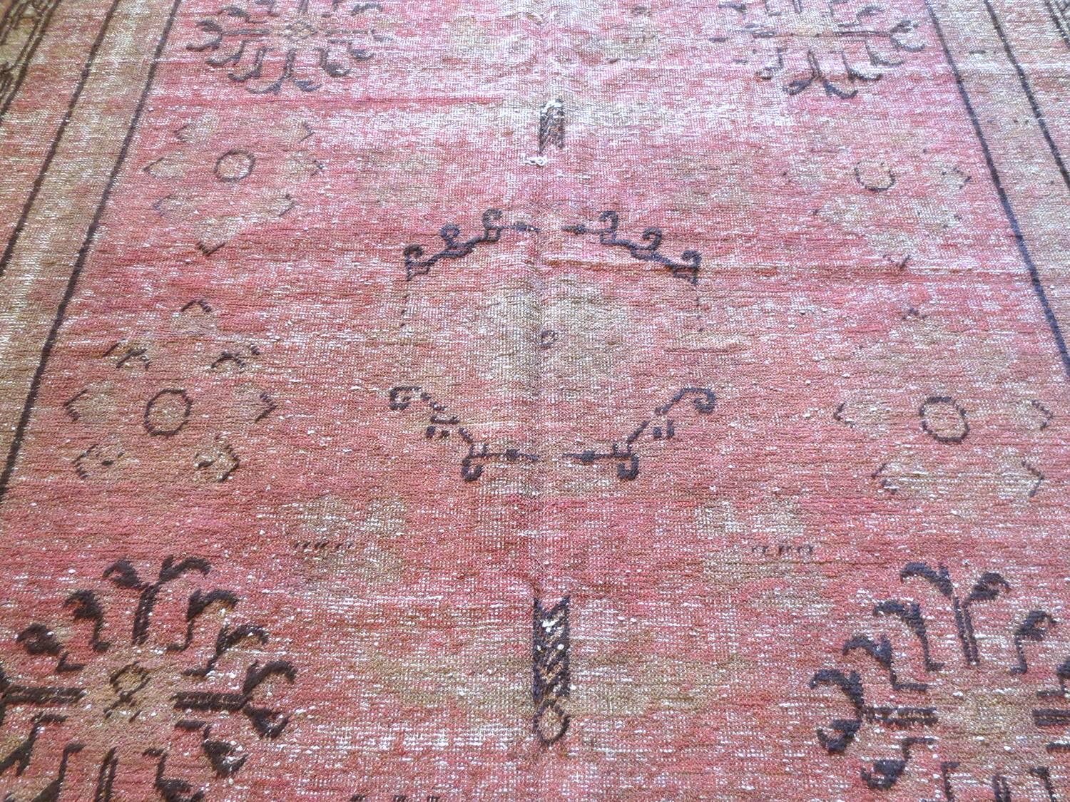 Dies ist ein antiker Samarkan-Teppich aus Ostturkestan, um 1900. Es hat ein schönes rosafarbenes Korallenfeld und Brauntöne in den Rändern. Das Design im Feld besteht aus stilisierten Blumen, Schmetterlingen, Granatäpfeln, abstrakten Formen und
