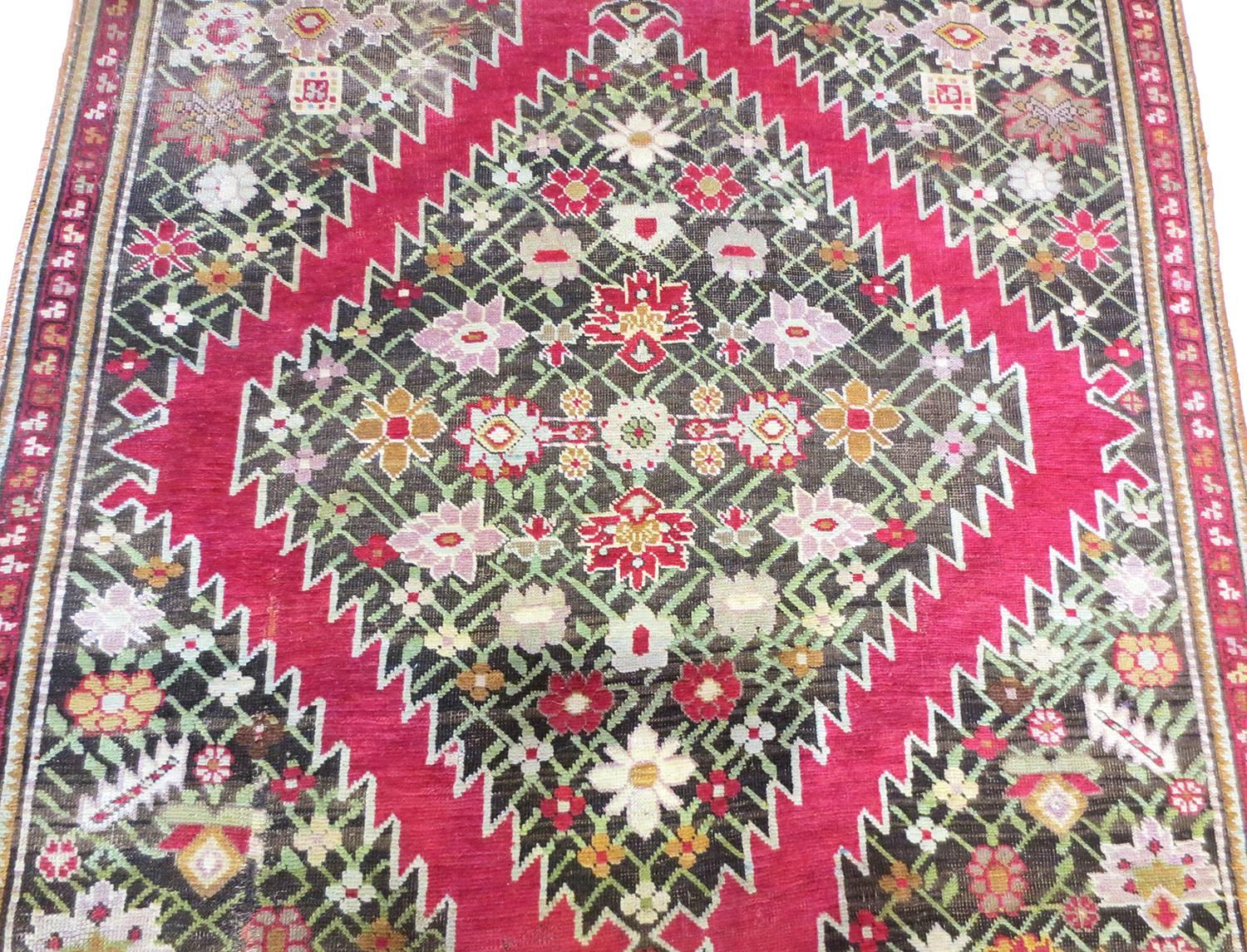 This is an antique Karabagh runner from the Caucasus area, circa 1900s. It features four large diamond medallions aligning through the centre, inset with floral designs that connect together through a latticework of vines. The palette of the carpet