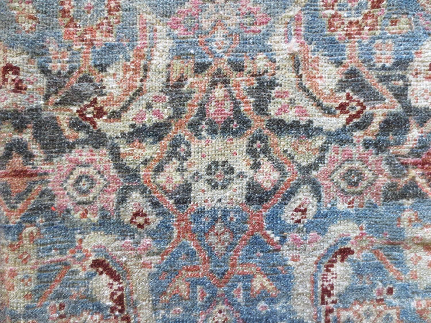 This is antique Persian Malayer runner circa 1880s showcases a lively display of activity. Brighter hues of reds, oranges, ivory, taupe greens contrast nicely against a beautiful light grey, charcoal blue field and allow the floral pattern to Stand