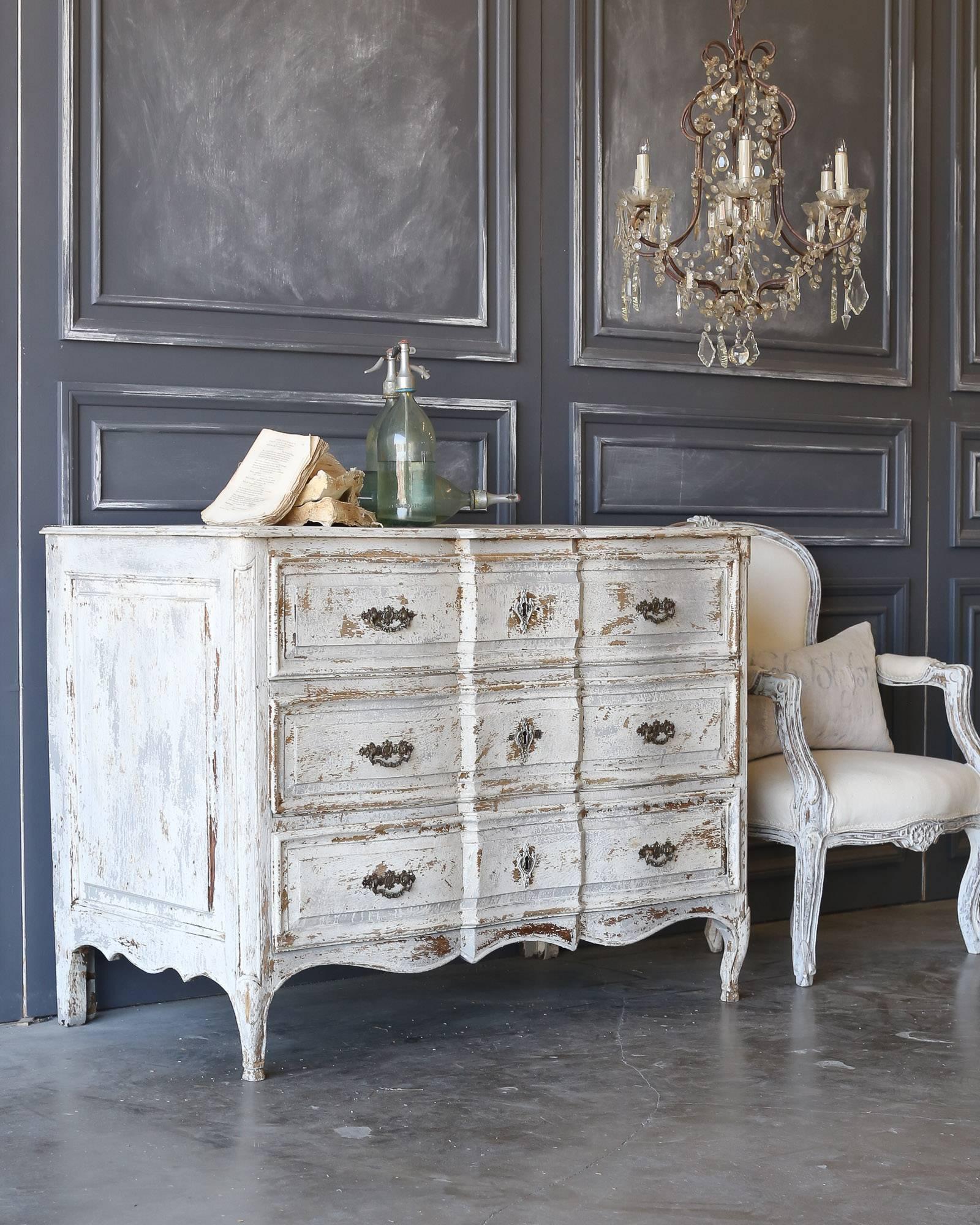 Charming large-scale commode with three drawers. This antique commode features a gorgeous painted patina with very ornate hardware, classic lines and legs carved in Louis XV style.