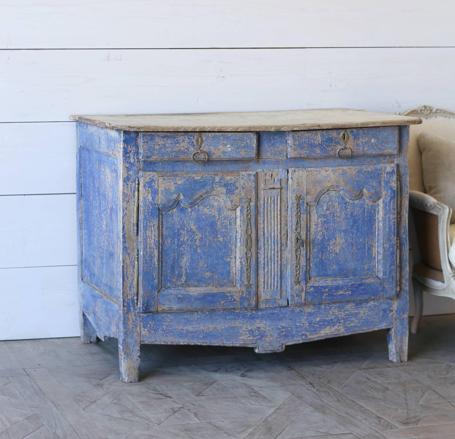 Provincial two-door cabinet in distressed cobalt blue finish revealing old French oak. Top has gorgeous patina of peach and wood paired back to charming antique hardware. A unique piece to brighten any room.