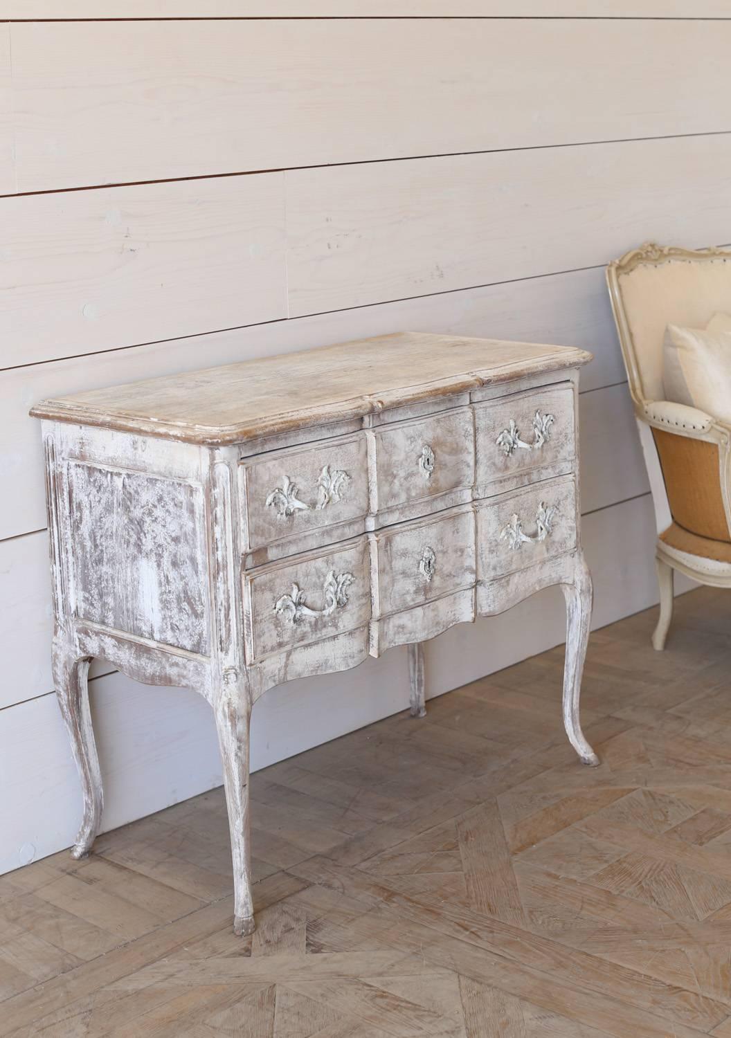 Lovely antique commode with two drawers. Elegant serpentine shape with original hardware in a fresh, warm white-washed finish.