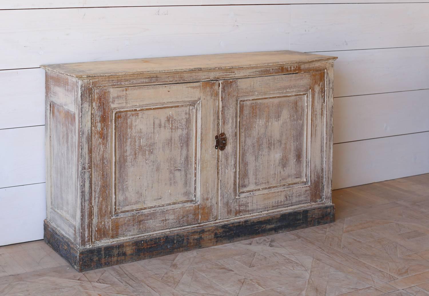 Charming antique cabinet from Le Moulin a Vent in Provence. Cafe au Lait in color, rubbed back to a natural wood finish sitting upon a heavily distressed black bottom. Two cabinet doors open to a single shelf with plenty of storage.