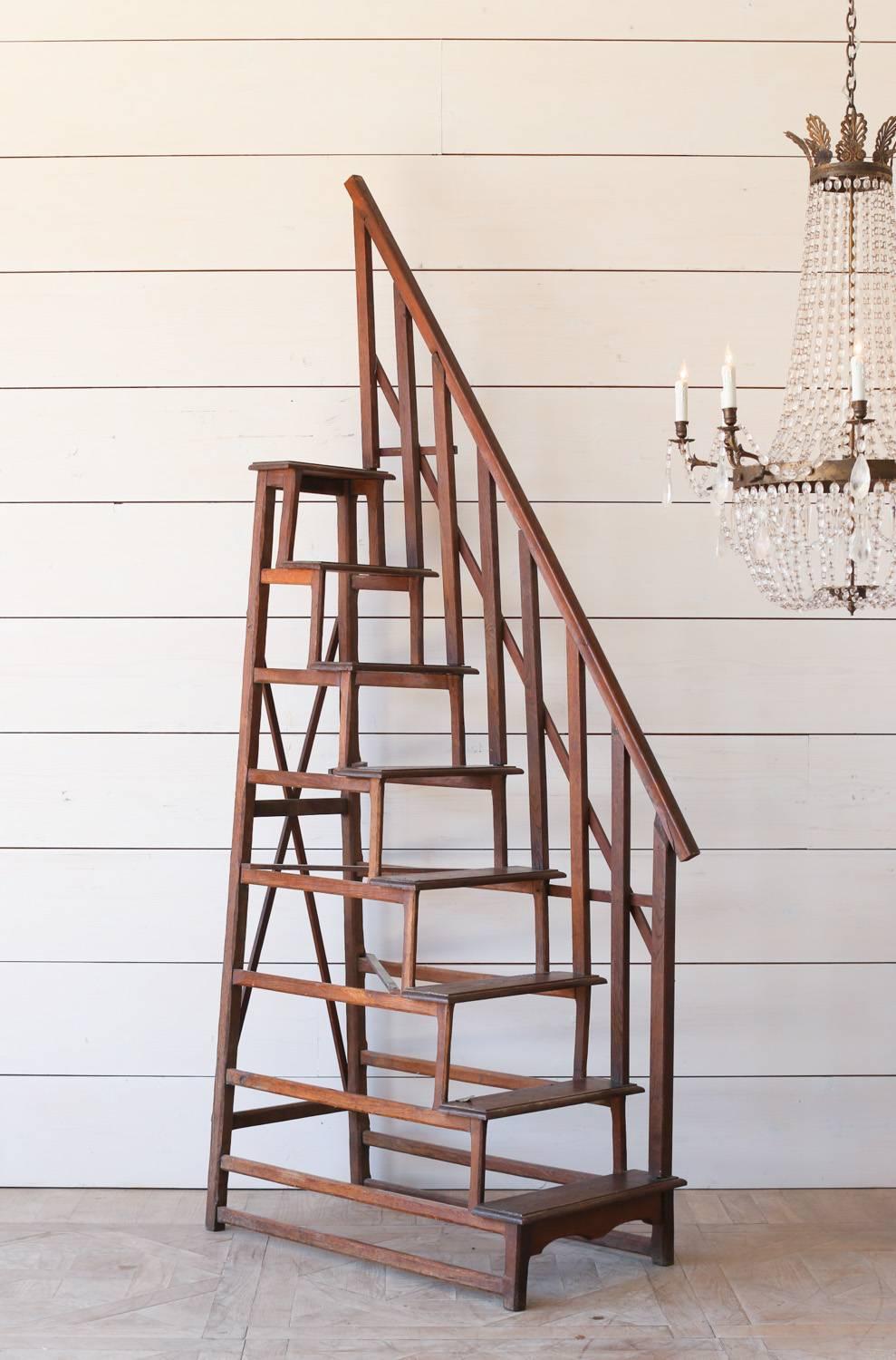 Linear antique library ladder in natural wood finish. This unique piece is from the area of Nimes, Provence and was used to access books on taller shelves. Add old world charm to your modern library, bedroom, or simply drape garments over the side