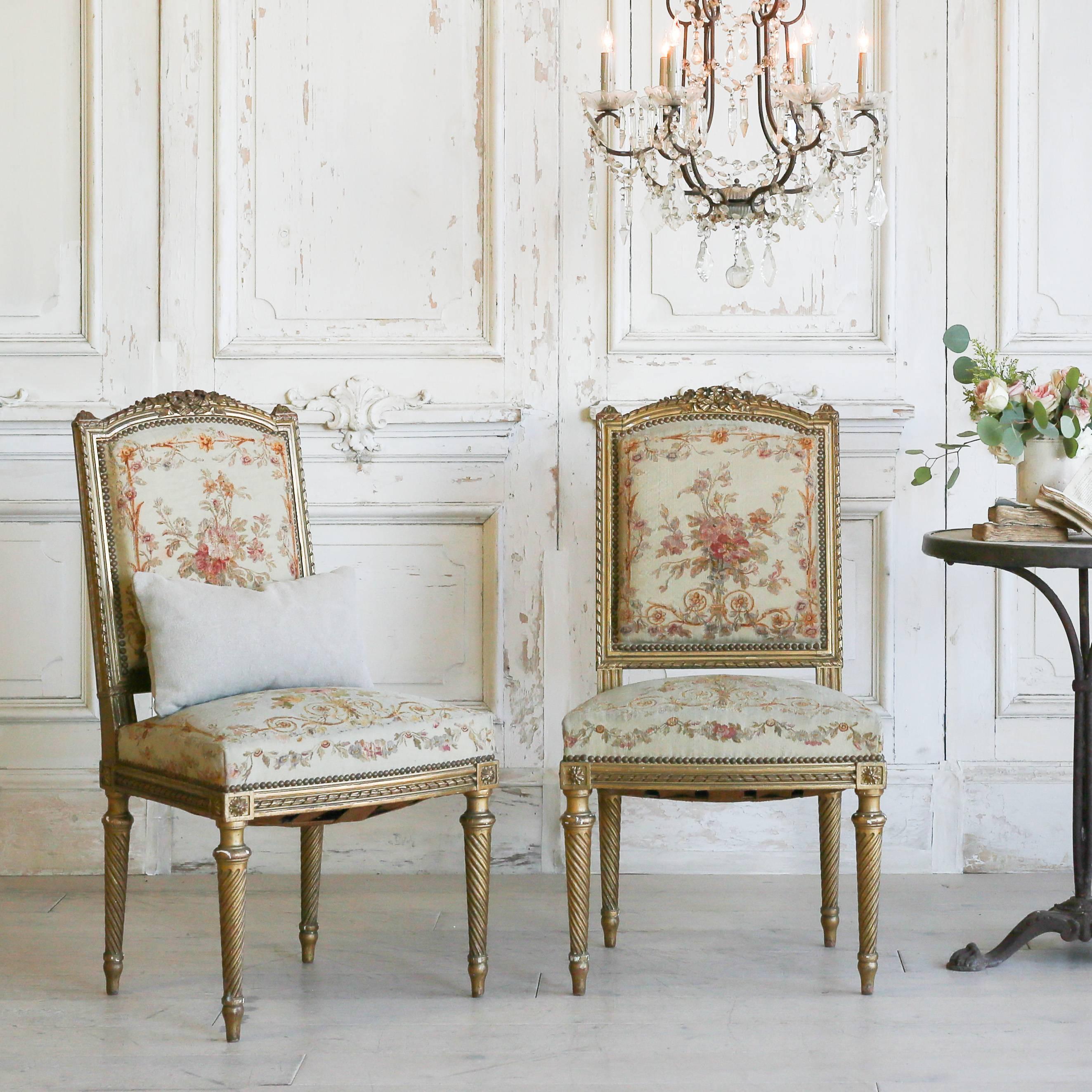 Lovely pair of Louis XVI side chairs in gilt. These chairs have original fabric securely tacked with beautifully turned legs. A delicately carved crest and shallow finials decorate the back rest. A beautiful addition to a cafe table or sitting area.