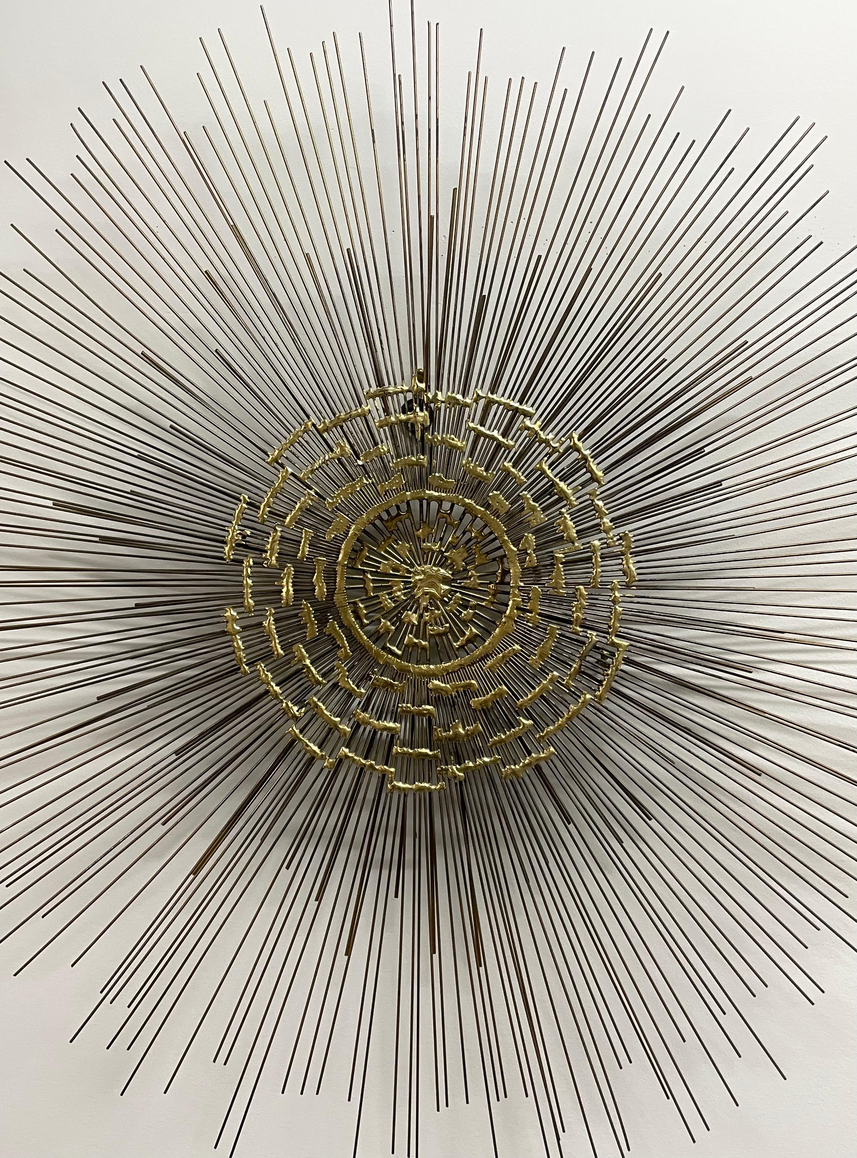 Bellissima scultura da parete brutalista a forma di stella attribuita a Curtis Jere. Questo pezzo è caratterizzato da un esclusivo motivo circolare con sottili aste in ottone che si irradiano. Misura 28