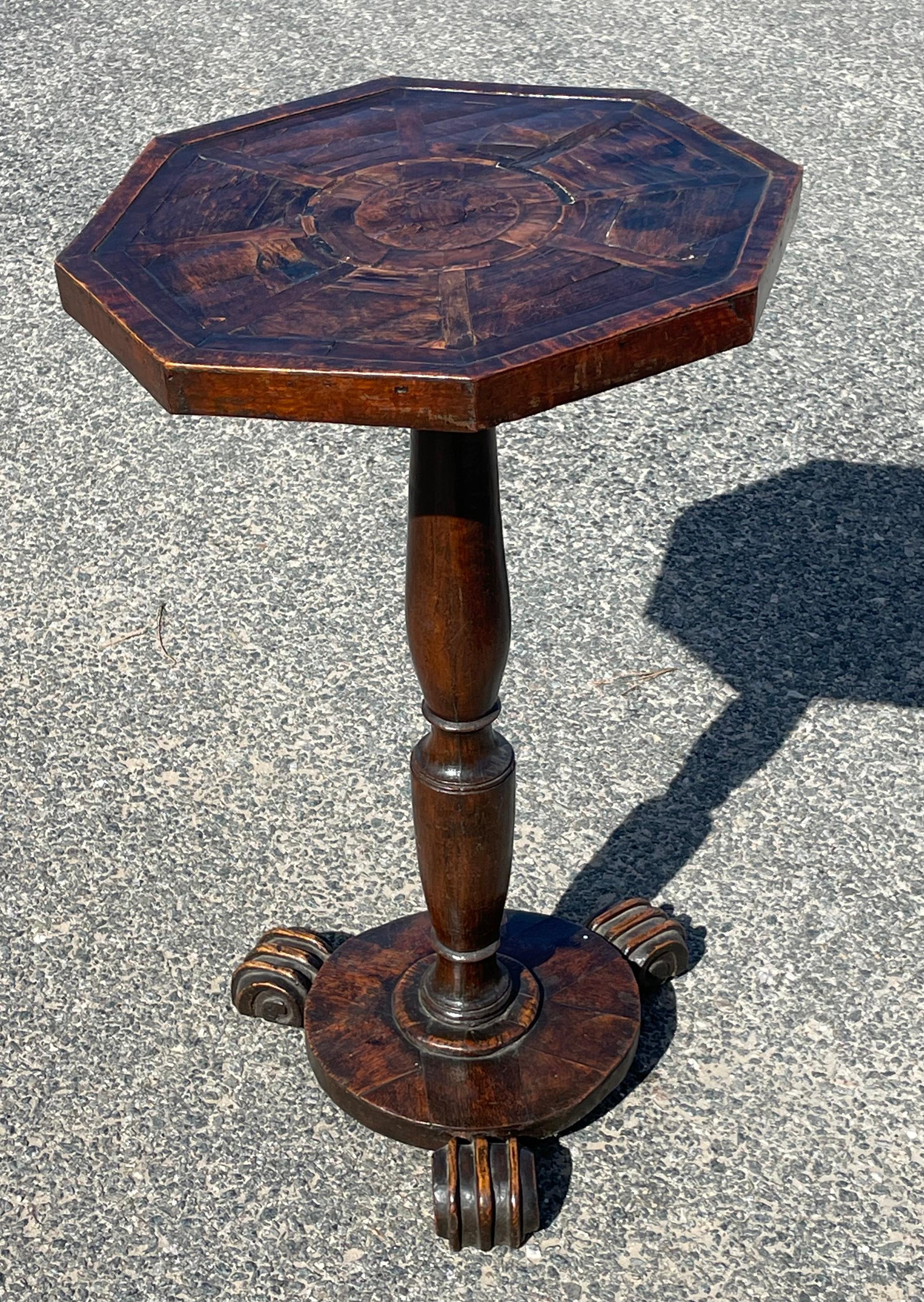 Diminutive 18th century English candle stand. Crafted from oak with inlaid octagonal top on turned pedestal and terminating in three claw feet.