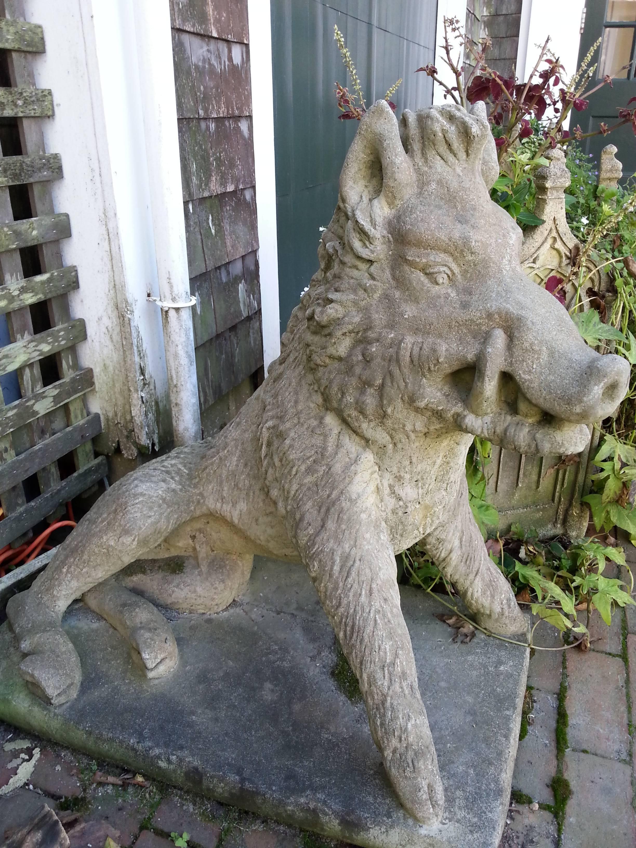 Pair of concrete boars garden statues for outdoor ornamentation.