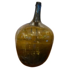Demi-joue / bonbonne en verre ambré-olive soufflé à la main, début du XXe siècle, vers 1900