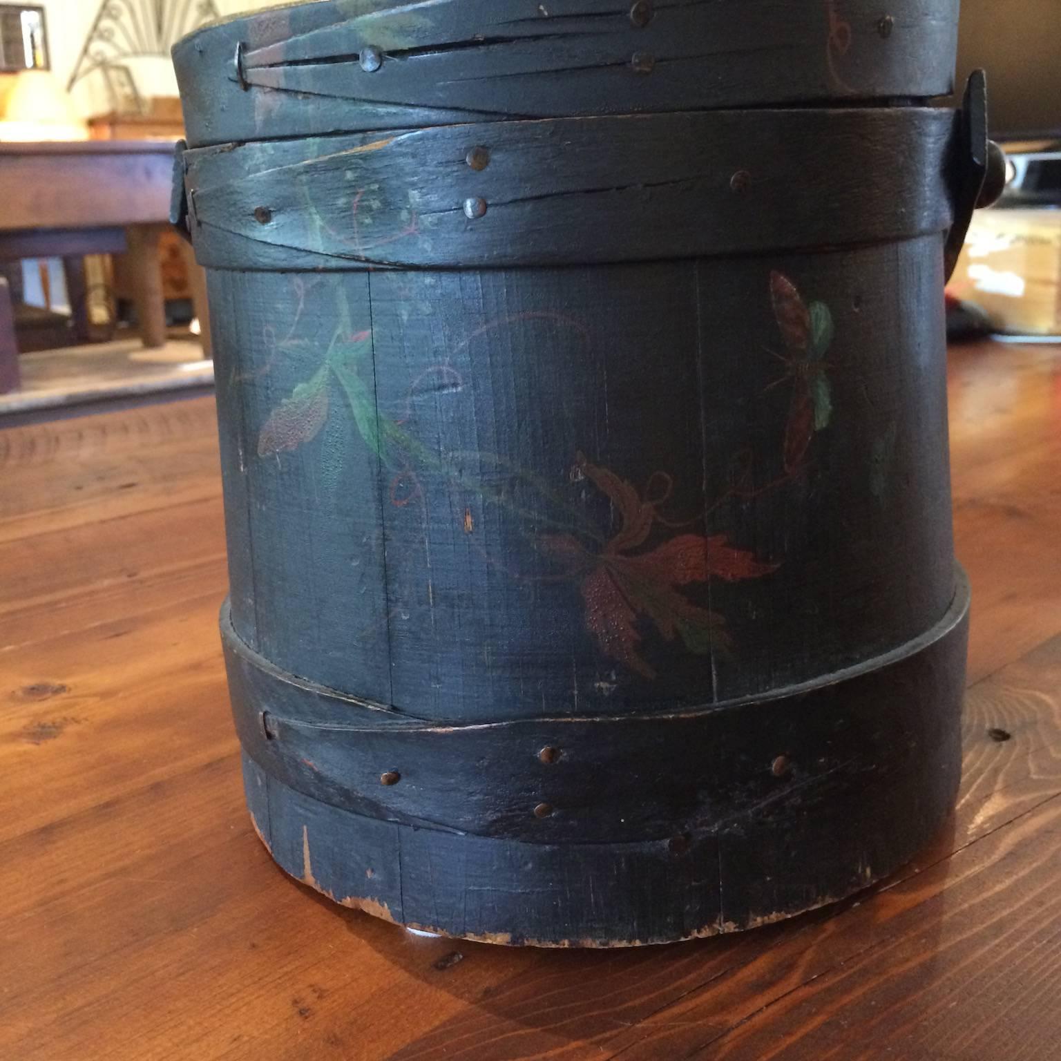 Black painted firkin with lid, decorated in leaf and vine motif.
