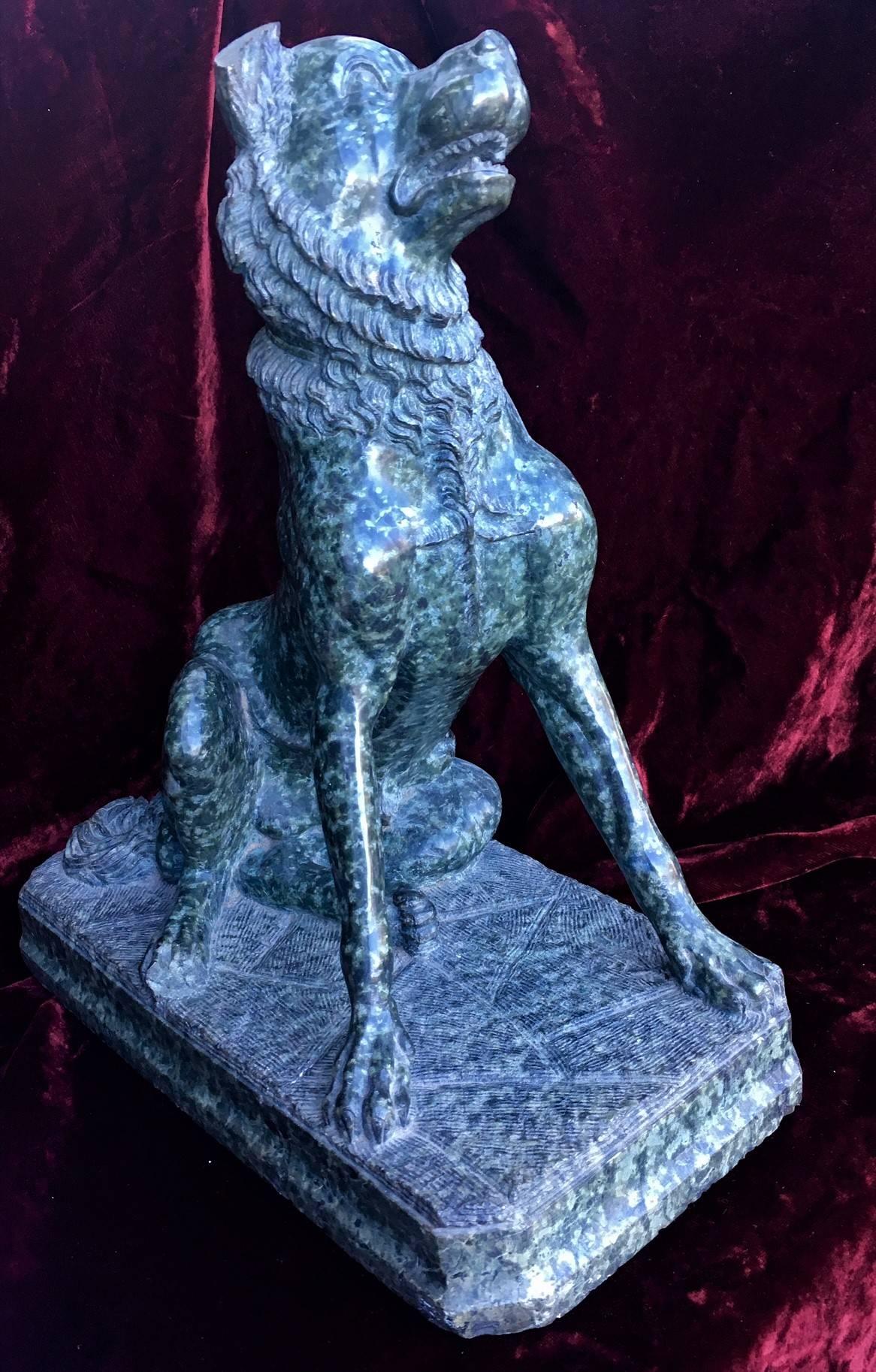 
The antique sculpture portrays a mastiff, sitting upright in an attentive pose with ears cocked, head canted, and mouth open. Hand carved from a block of green marble, unsigned. The sculpture is an exact copy in miniature of one of a pair of such