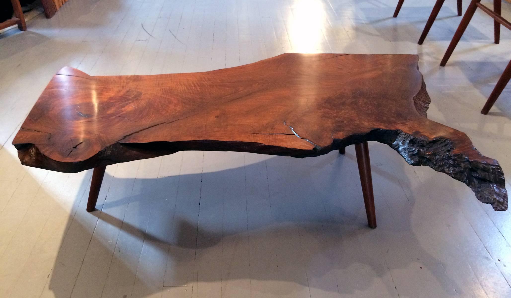 One of the earliest walnut slab coffee table handcrafted by George Nakashima in hi New Hope Studio. It was purchased by the original owner in 1959 and cherished in the family ever since. The walnut slab on top resembles the shape of America and the