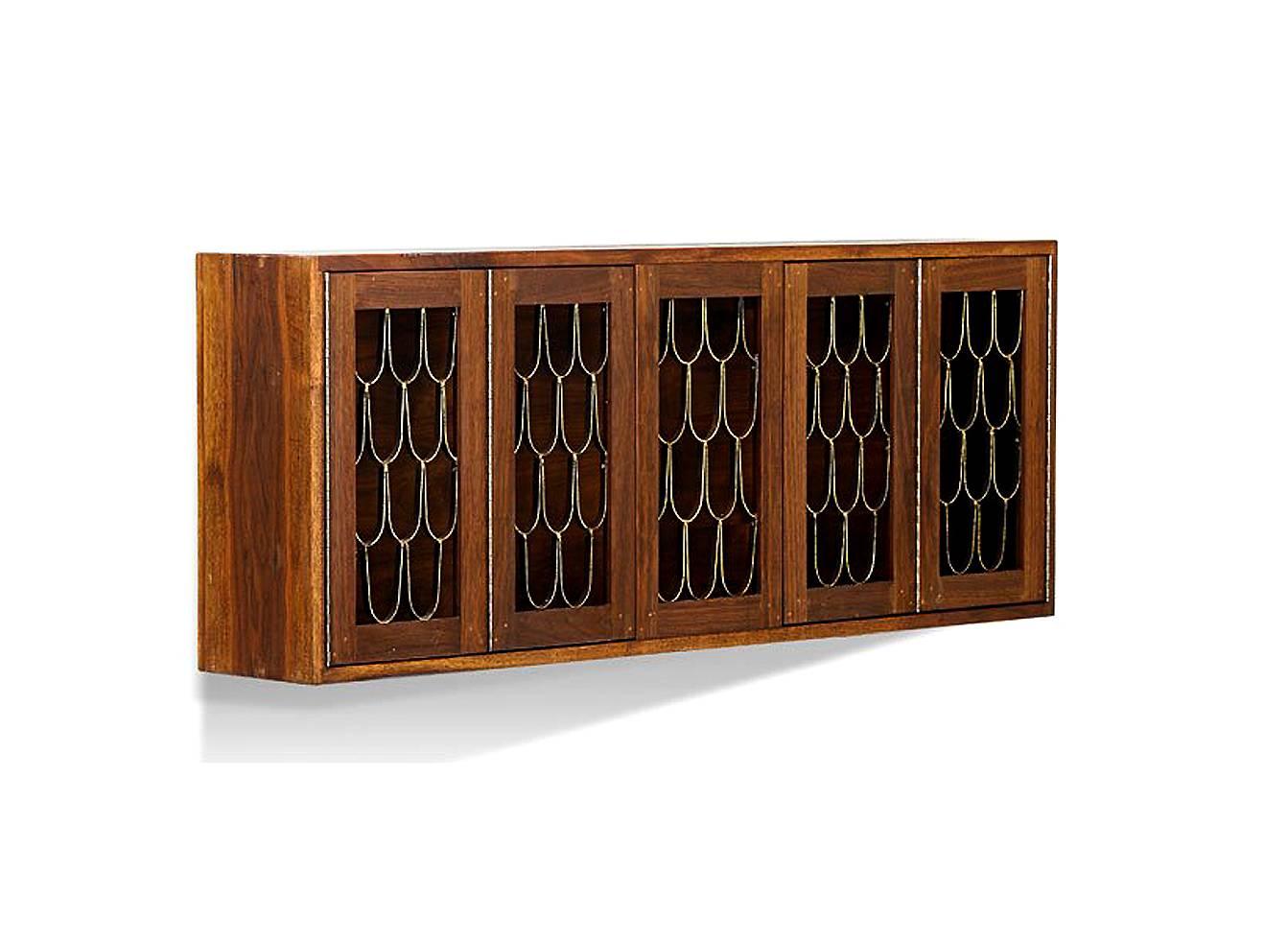 An early wall hanging walnut cabinet crafted in collaboration between Paul Evans (1931 - 1987) and Phillip Lloyd Powell (1919 - 2008) when they shared a studio and showroom in New Hope, PA. The cabinet was among the work dated 1960s when the artists