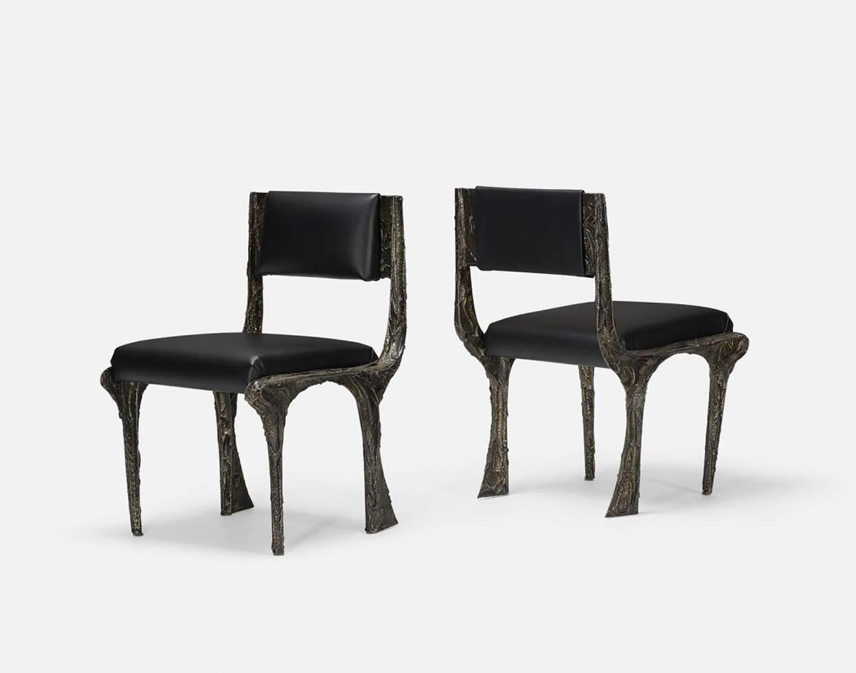 A custom pair of armchairs with leather seats by Paul Evans in sculpted bronze series, circa 1970s. The rare model is a variation of the standard PE chair with playing with the shapes of the legs, and was likely a custom commission directly from