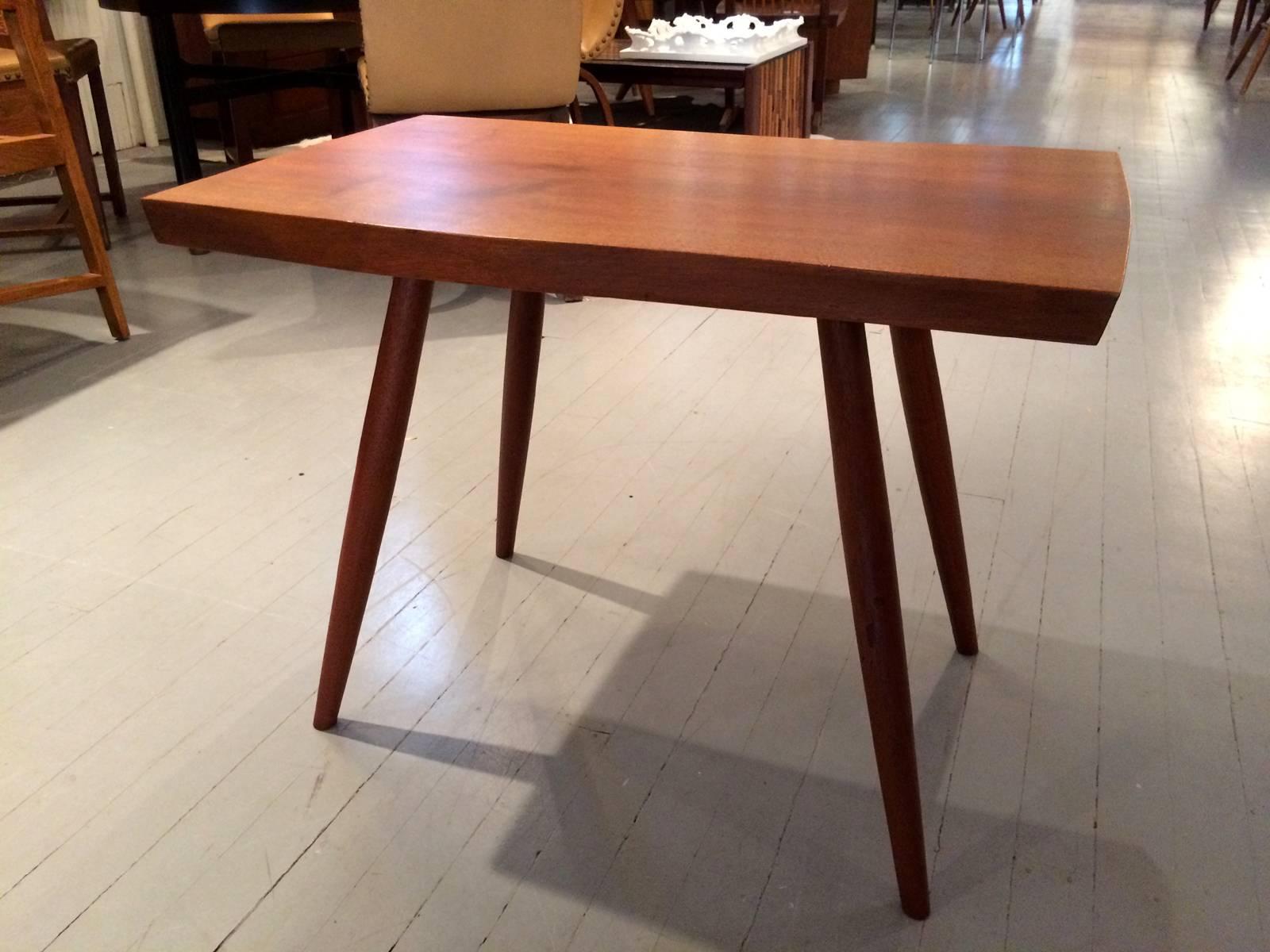 An early side table made from a free-edged walnut plank with four spindle legs in 1961, by George Nakashima. This table has an excellent provenance as it was ordered from George Nakashima Studio in 1961 and installed in a house in Michigan designed