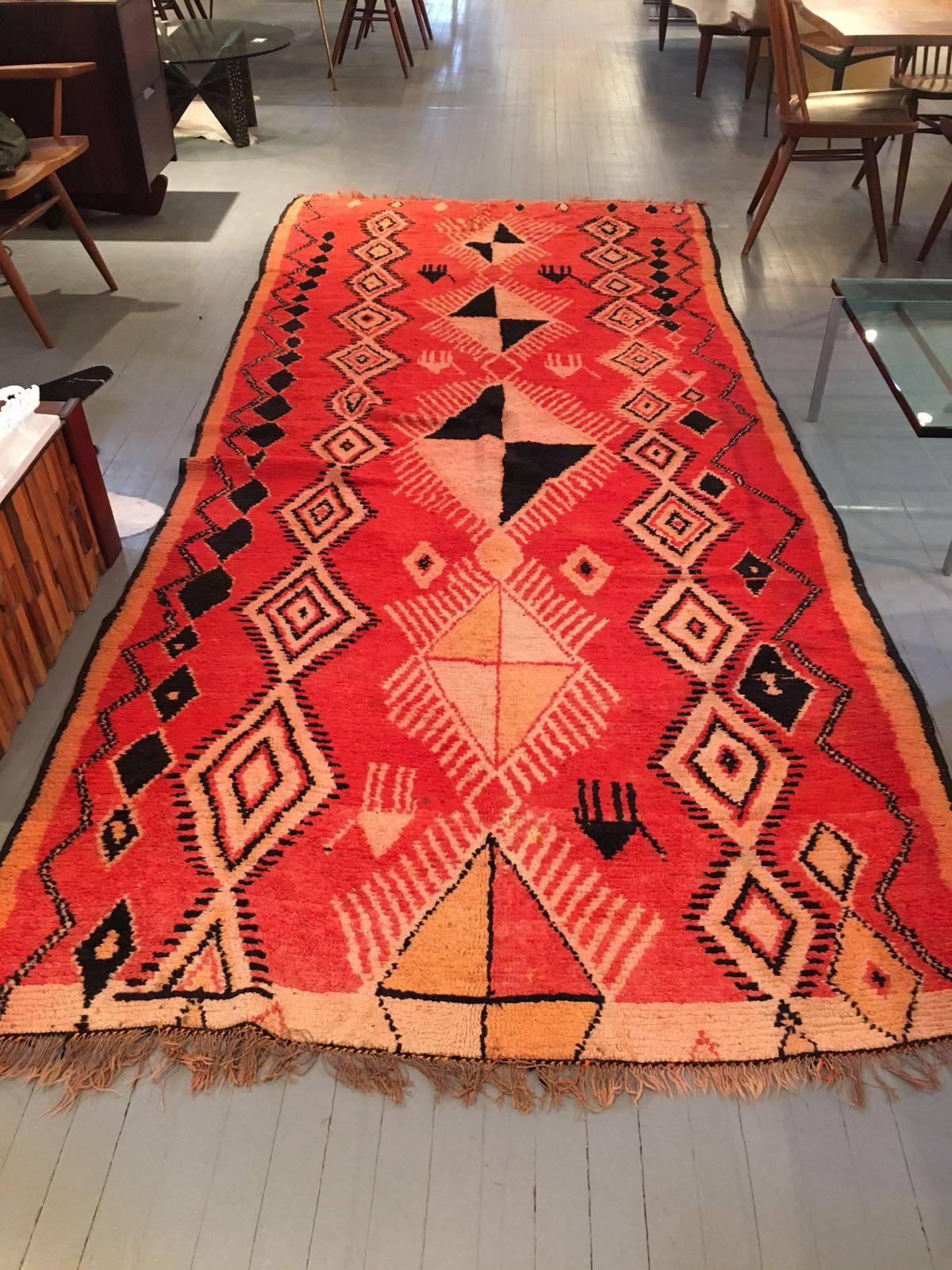 A striking Berber wool long rug with brilliant colors and geometrical patterns featuring repeating central medallions and borders, this rug was woven in Morocco by the tribal Berbers, circa second half of the 20th century. An impressive 140 inches