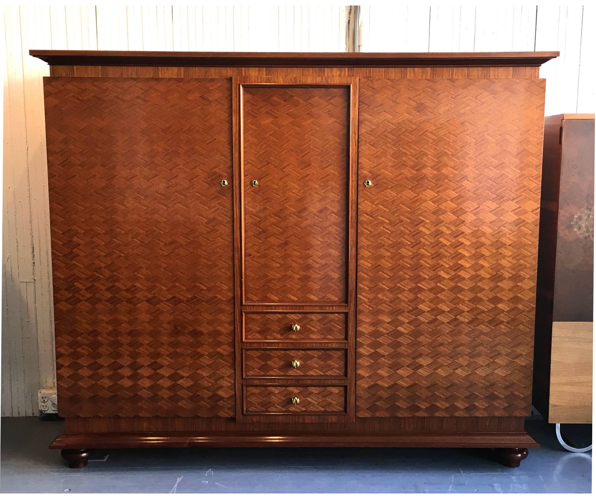 A large cabinet with parquetry design by Jules Leleu Paris, Model no. 4178. Designed in 1951 and this example is dated to 1953. Functioning as an Armoire for wardrobe, the cabinet features three storage sections with numerous adjustable shelves and