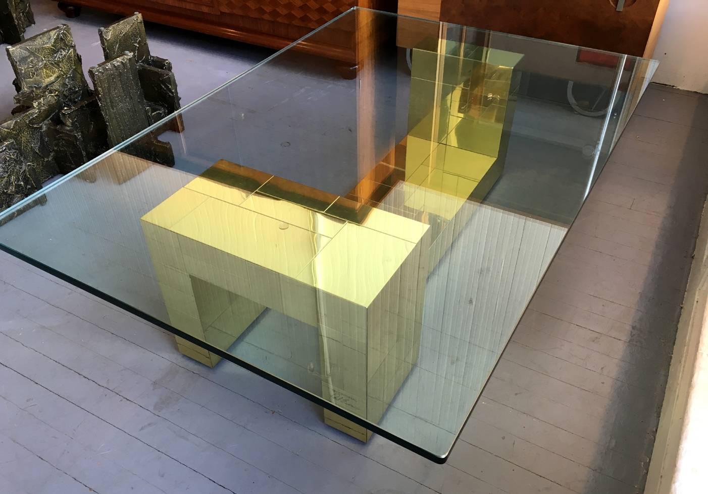 Signature cityscape series coffee table by Paul Evans. Two asymmetrical brass and plated bases support a thick glass top. Signed as original Paul Evans. The two bases currently support a 0.5 inch thick glass top that measures 56 by 38 but can be