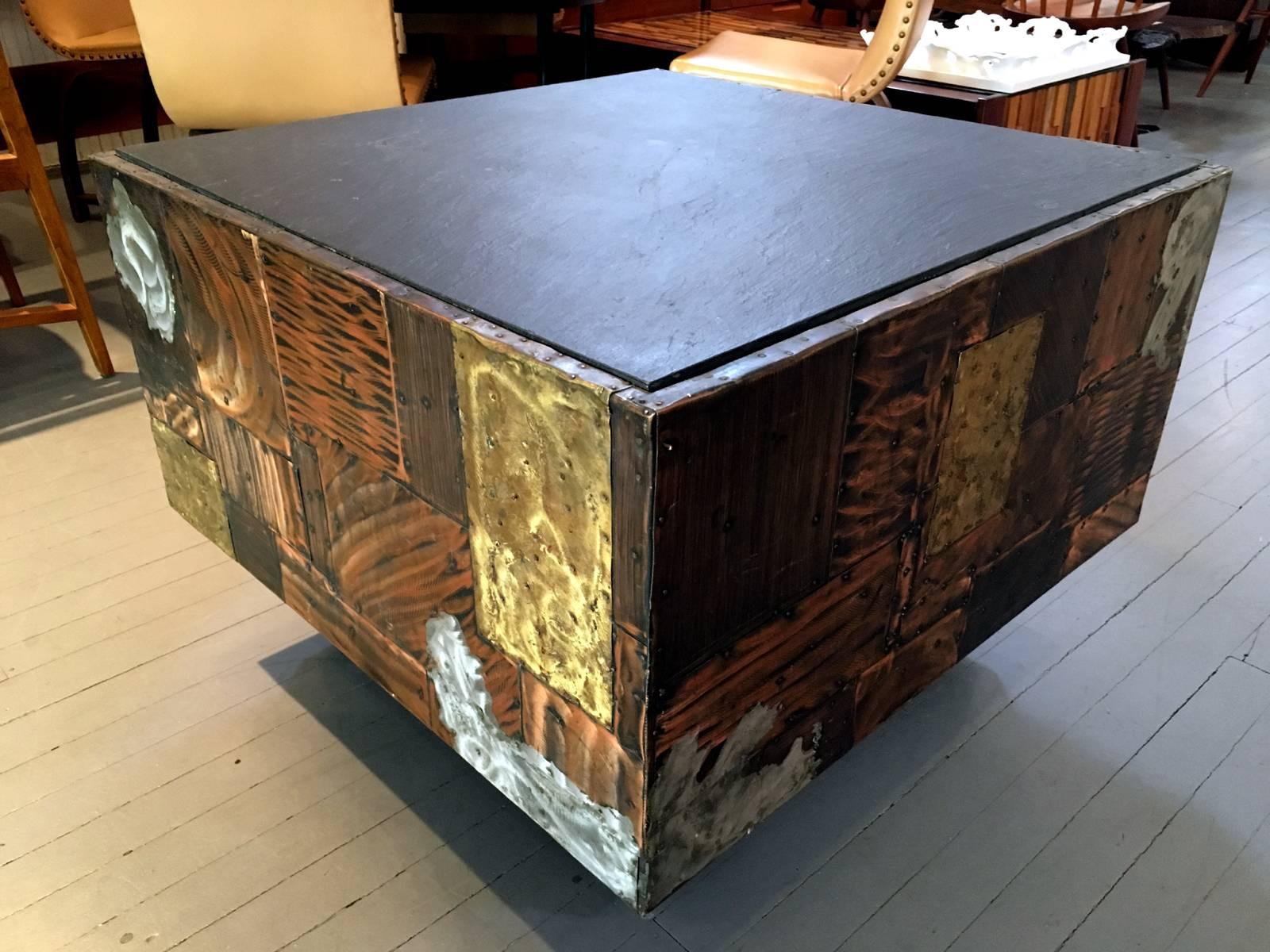 A beautiful table with signature metal patchwork crafted by Paul Evans in 1970s for Directional. Metal veneer consists of a variety of material such as copper, hammered brass and splashes of pewter, artistically patched with visible nail heads.