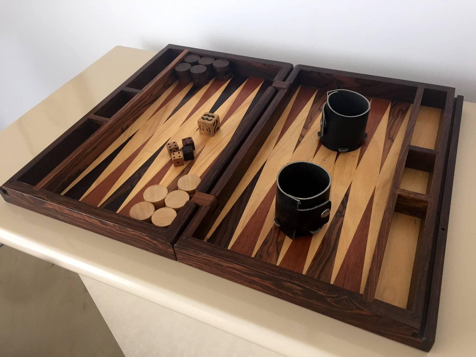 An amazing backgammon game set designed by Don Shoemaker and handcrafted by Señal S.A. Industrial designs in Mexico. The set was designed as a traveling suitcase with lockable handle. It is a complete set with discs, dices and even leather cups.