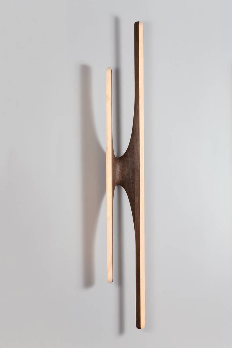 Haase seamlessly combines stone and wood in fluid compositions that serve functional ends in his breakout series of furniture. His 25 years experience as a sculptor are evident in the refined sculptural craftsmanship of his unique sconces as he
