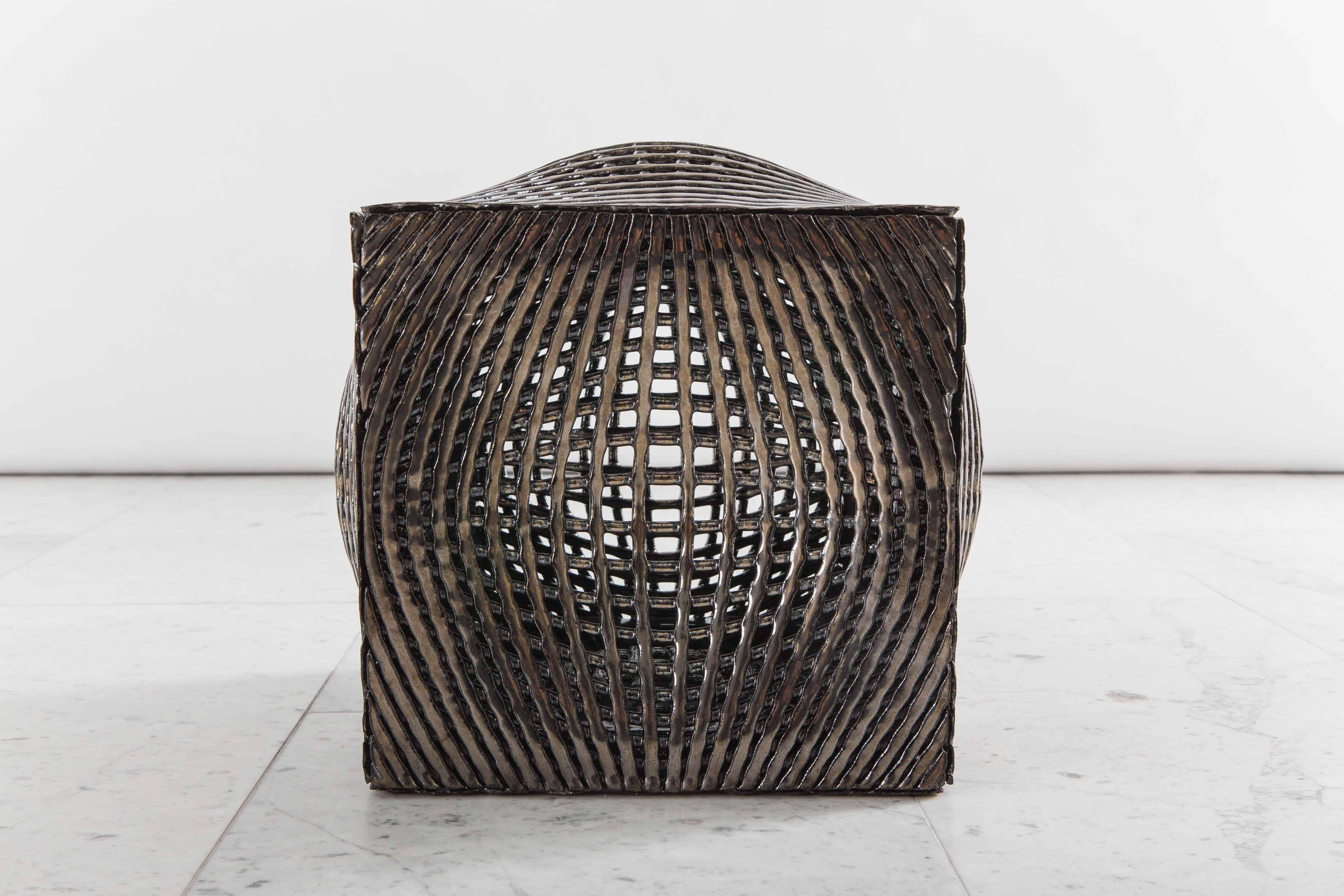 Colleen Carlson fuses together traditional ceramic techniques to create unique sculptures that emphasize texture, geometry, and light. The metallic cube, a tabletop objet d’art, is made of sculpture clay that been coated in a metallic glaze.
